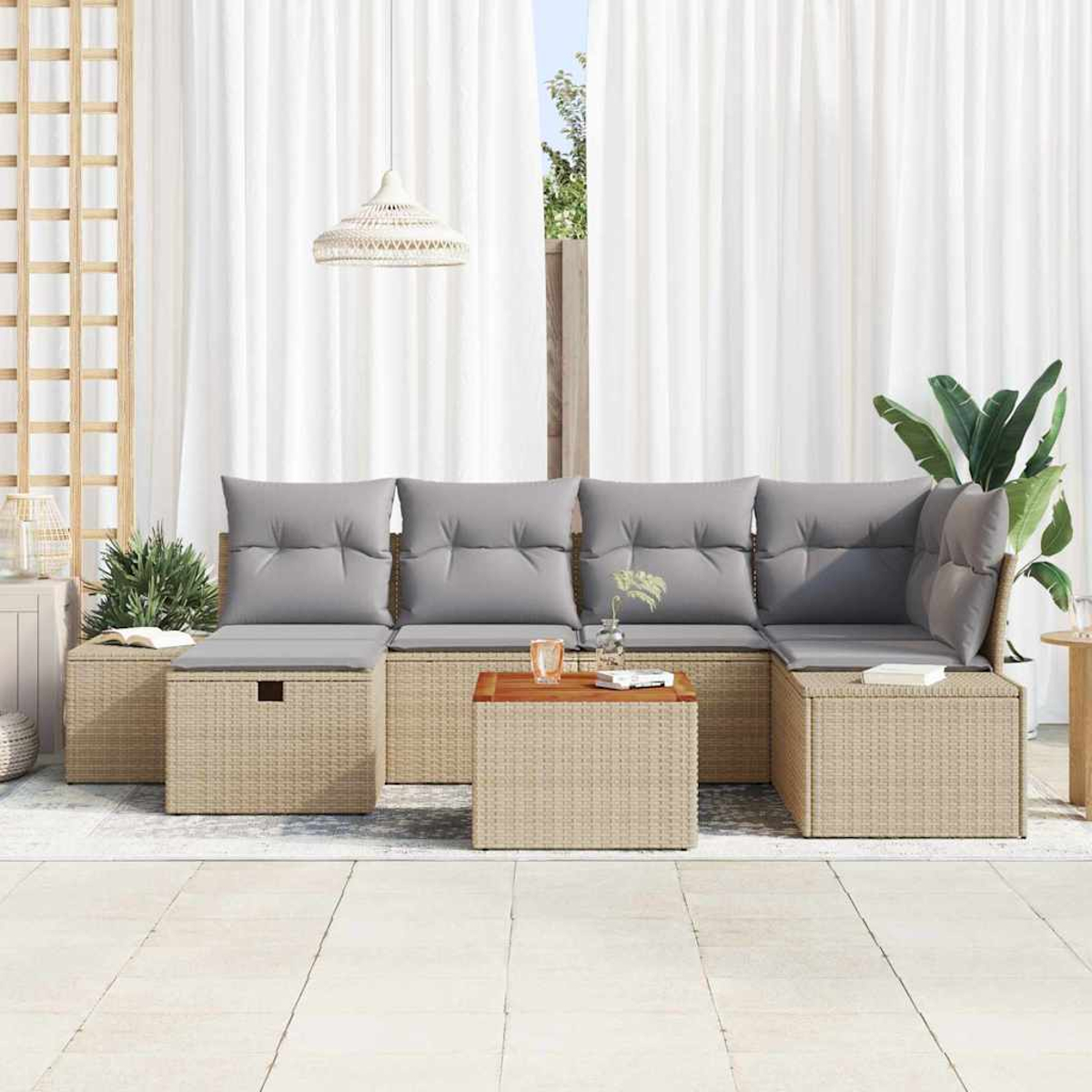 Outdoor-Sofa aus Korbgeflecht mit grauen Kissen. Ein Holztisch davor. Weiße Vorhänge und Pflanzen im Hintergrund.
