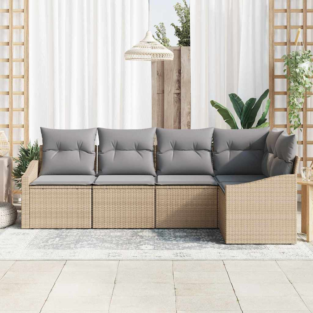 Ein beiges Ecksofa aus Korbgeflecht mit grauen Kissen steht auf einer Terrasse. Im Hintergrund befinden sich weiße Vorhänge und Pflanzen.