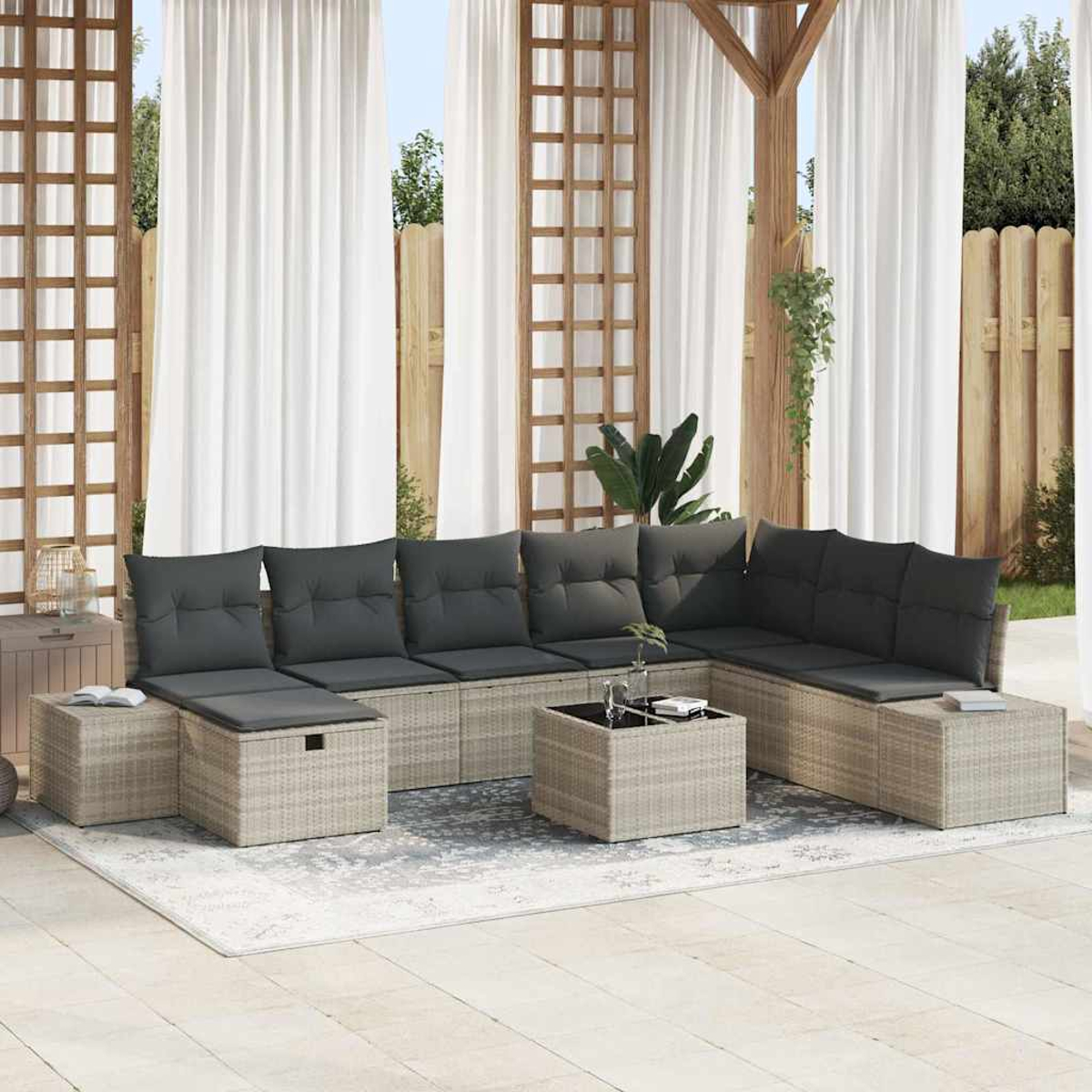 Outdoor-Ecksofa mit grauen Kissen auf einem Teppich. Weiße Vorhänge und Holzkonstruktion im Hintergrund.