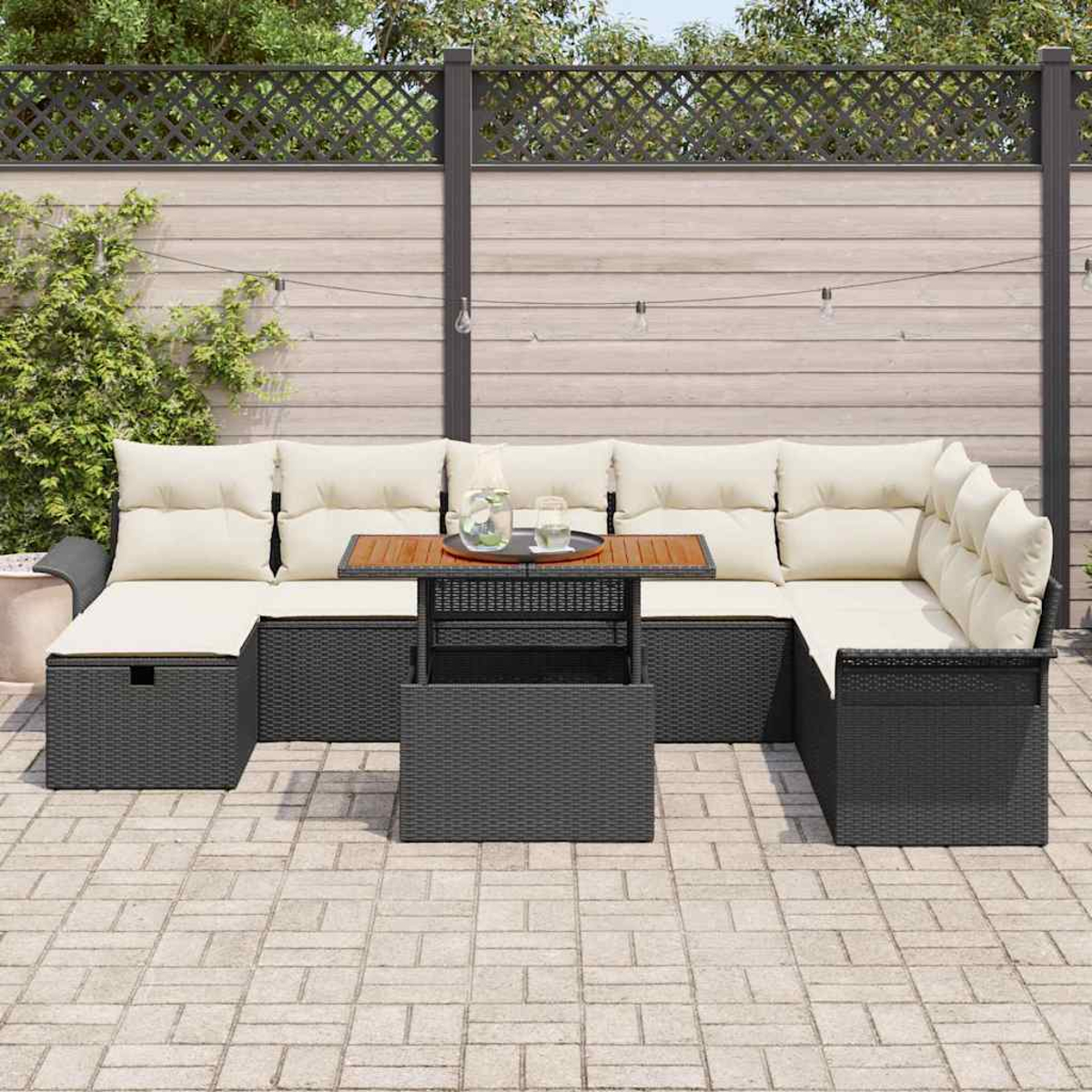 Outdoor-Ecksofa mit cremefarbenen Kissen und einem Holztisch in der Mitte. Die Szene spielt sich auf einer gepflasterten Terrasse mit Holzzaun ab.