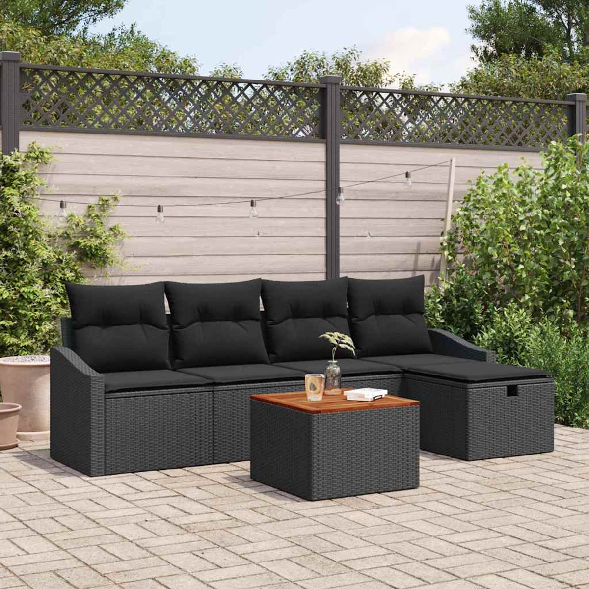Terrassenset im Freien. Schwarzes Korbmöbel-Sofa mit Kissen, passender Ottoman und Couchtisch mit Holzplatte. Ziegel-Patio und Zaun.