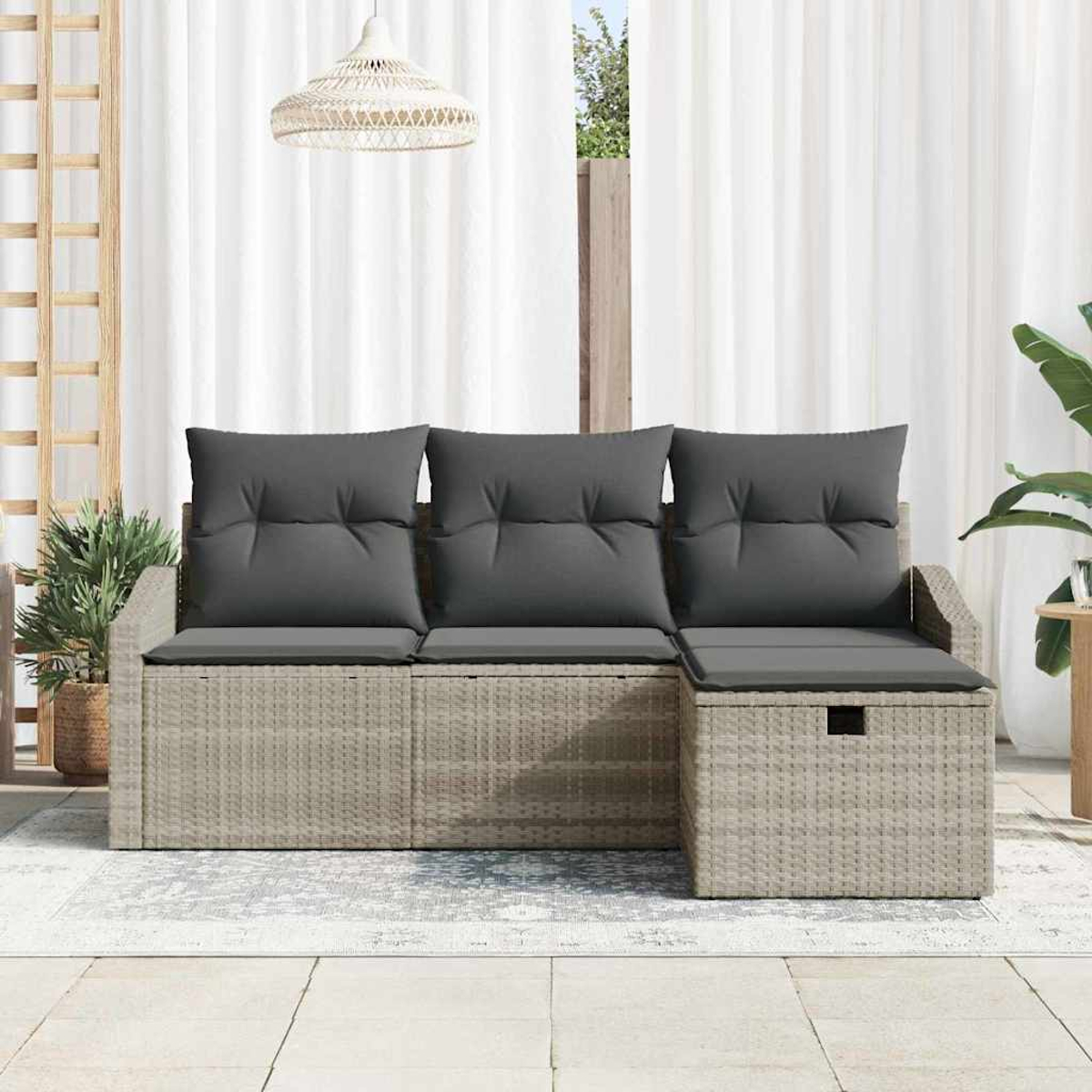 Outdoor-Rattansofa mit grauen Kissen. Weiße Vorhänge im Hintergrund. Eine Hängelampe und eine Pflanze sind ebenfalls zu sehen.