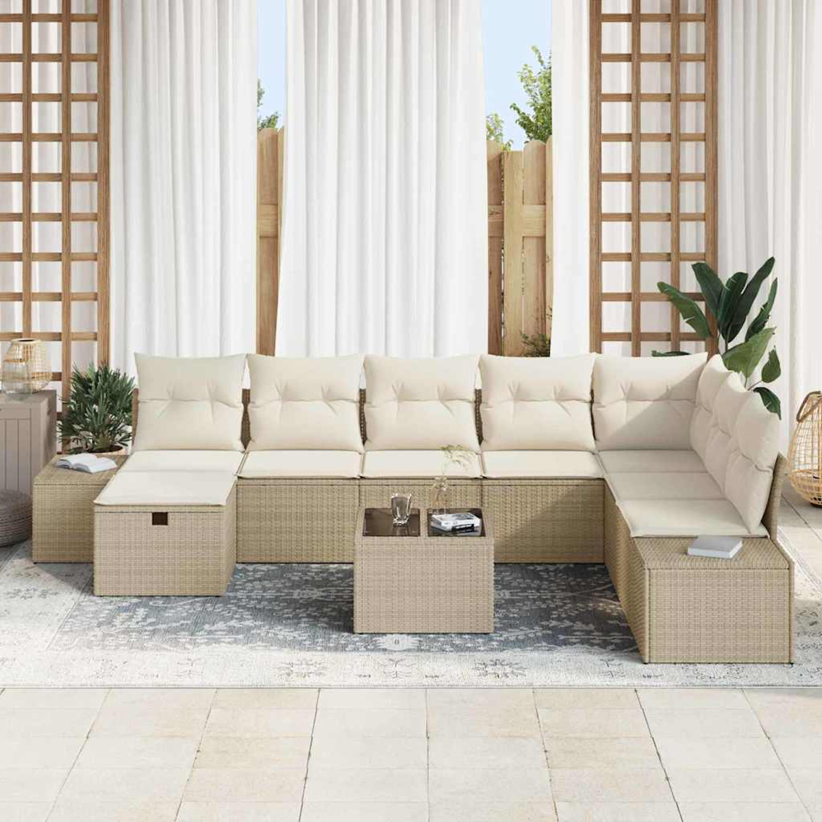 Ein Outdoor-Wicker-Ecksofa mit cremefarbenen Kissen. Ein kleiner Tisch mit Getränken und einem Buch steht auf einem gemusterten Teppich.