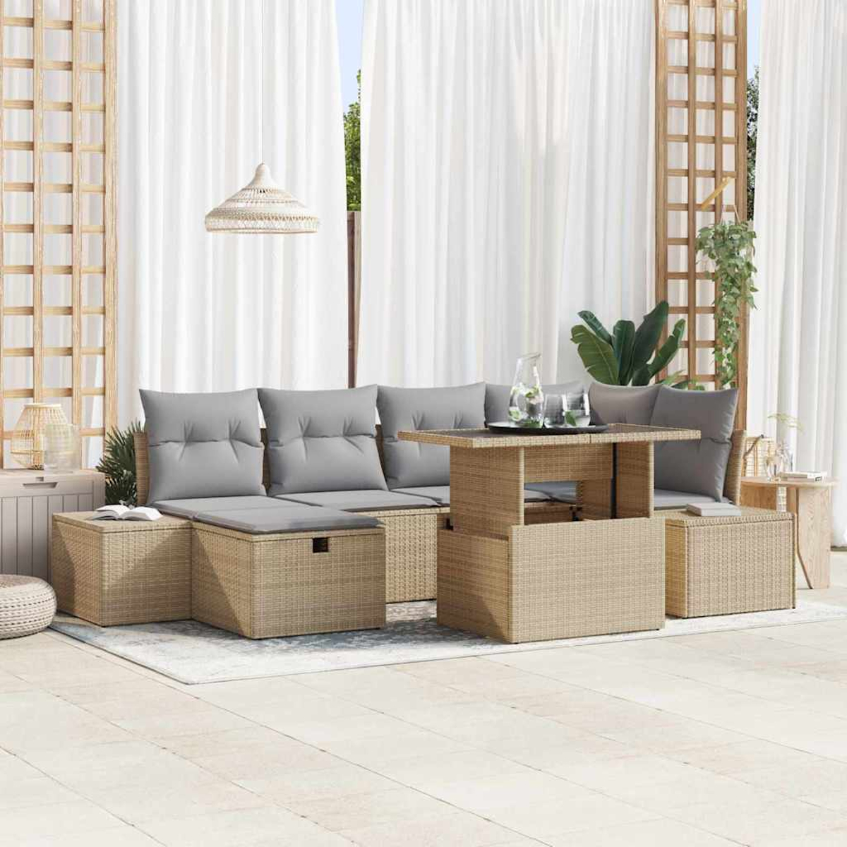 Terrassenset im Freien mit beigen Korbmöbeln, grauen Kissen und einem Tisch mit Hubfunktion. Weiße Vorhänge und Holzgitter im Hintergrund.