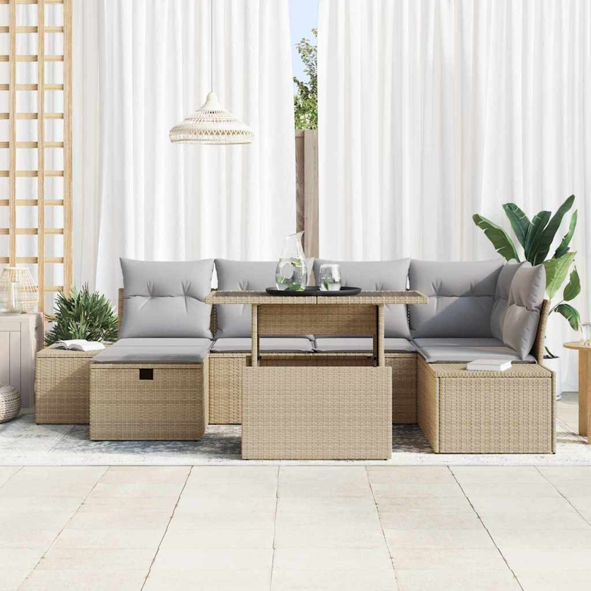Rattan-Sofa im Freien mit grauen Kissen, einem Tisch mit Gläsern und weißen Vorhängen.