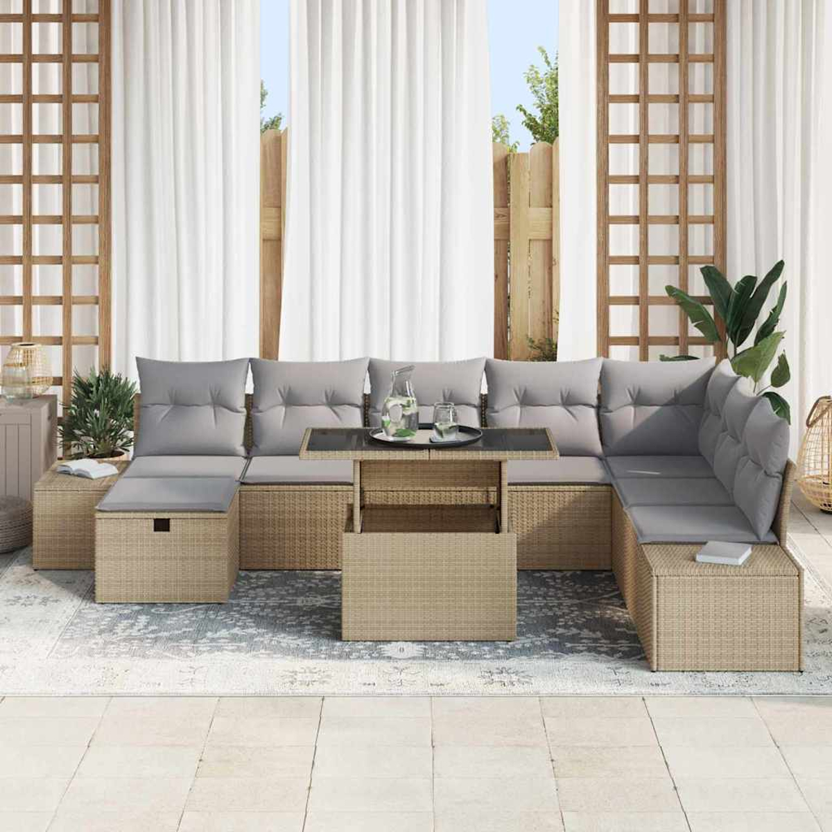 Outdoor-Ecksofa mit grauen Kissen und einem Couchtisch mit Glasplatte. Weiße Vorhänge im Hintergrund, Pflanzen und ein hellfarbiger Teppich.