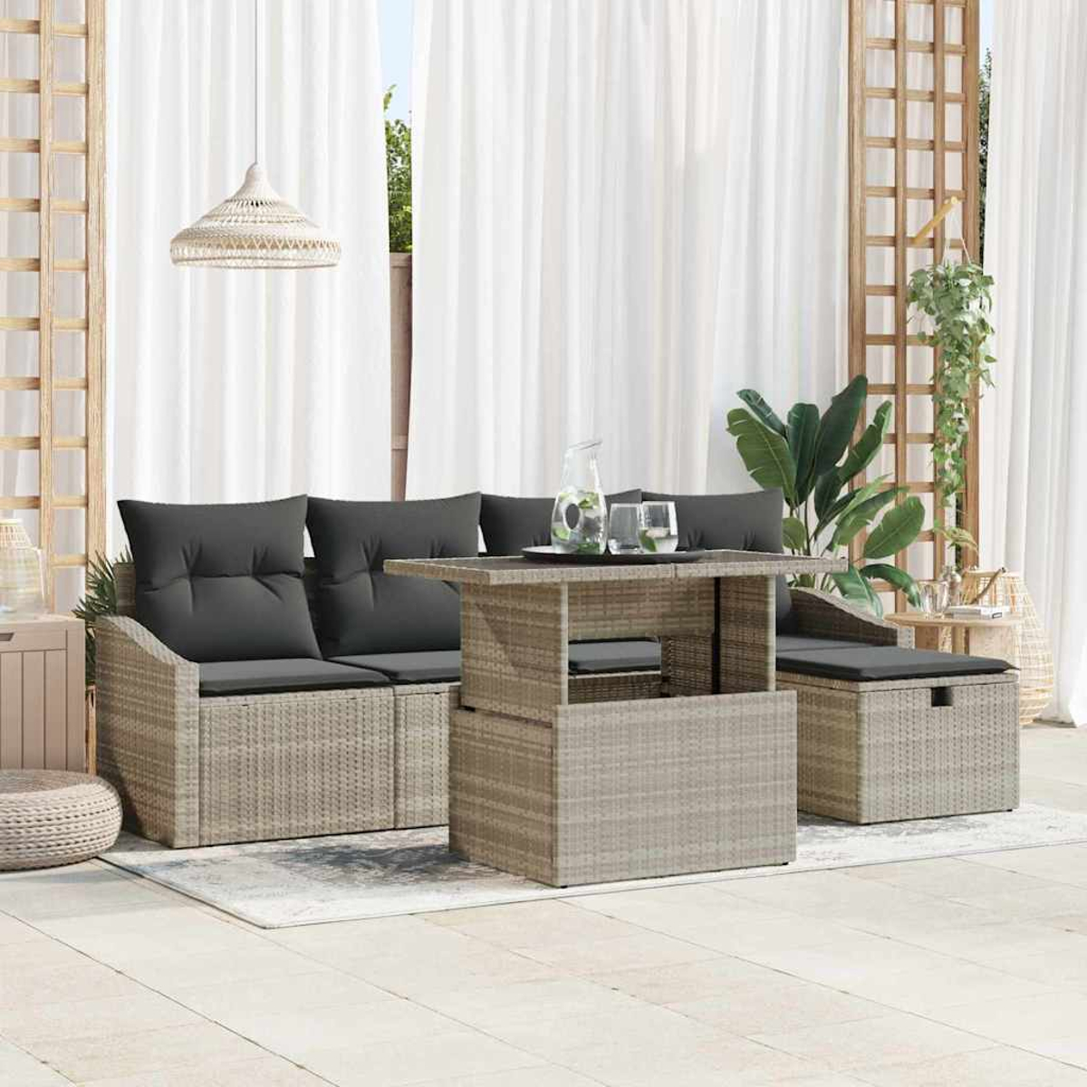 Gartenmöbel-Set mit grauen Kissen, einem Tisch und einer Aufbewahrungsbank. Weiße Vorhänge und eine Hängelampe im Hintergrund.