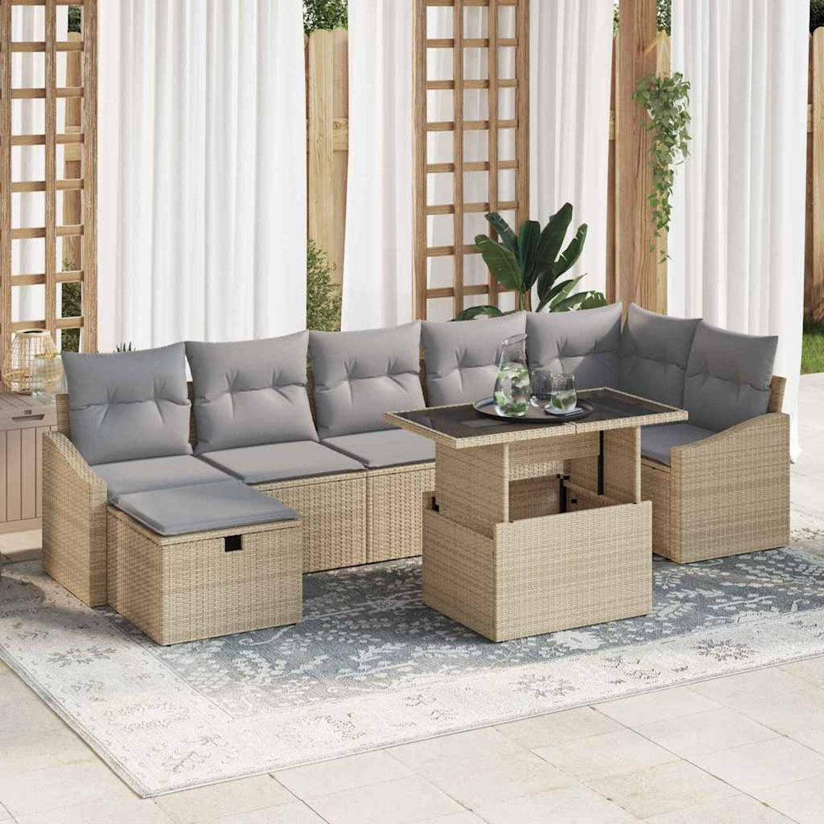 Outdoor-Rattan-Sofagarnitur mit grauen Kissen, einem Tisch mit Hubfunktion und weißen Vorhängen im Hintergrund.
