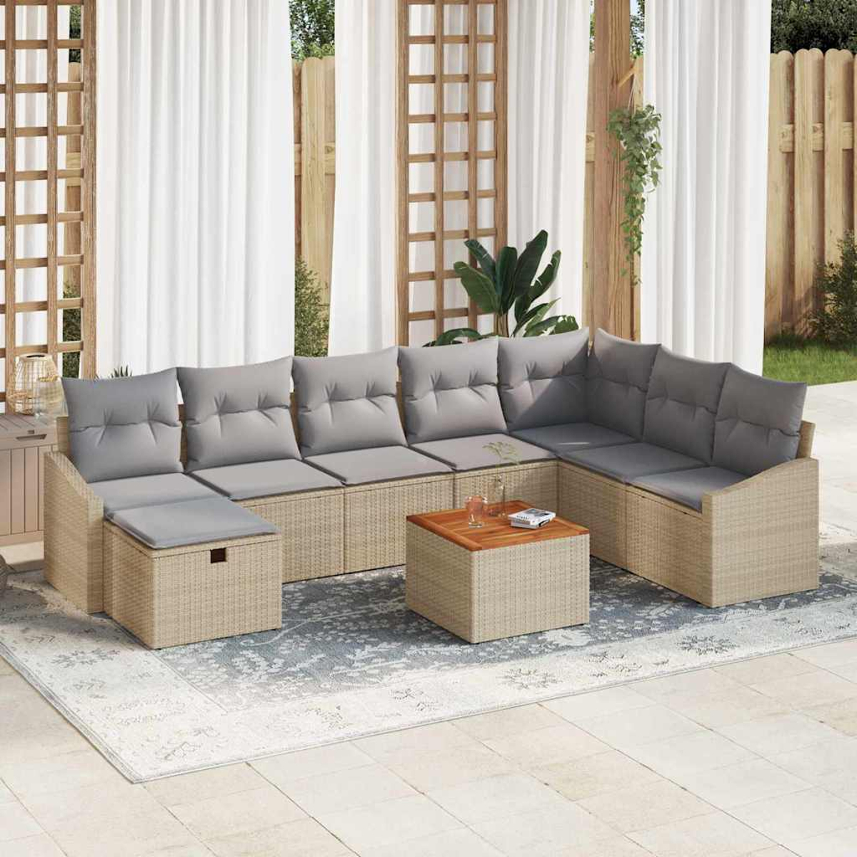 Outdoor-Ecksofa mit grauen Kissen und einem Holztisch auf einem gemusterten Teppich. Vorhänge und ein Holzzaun sind im Hintergrund.