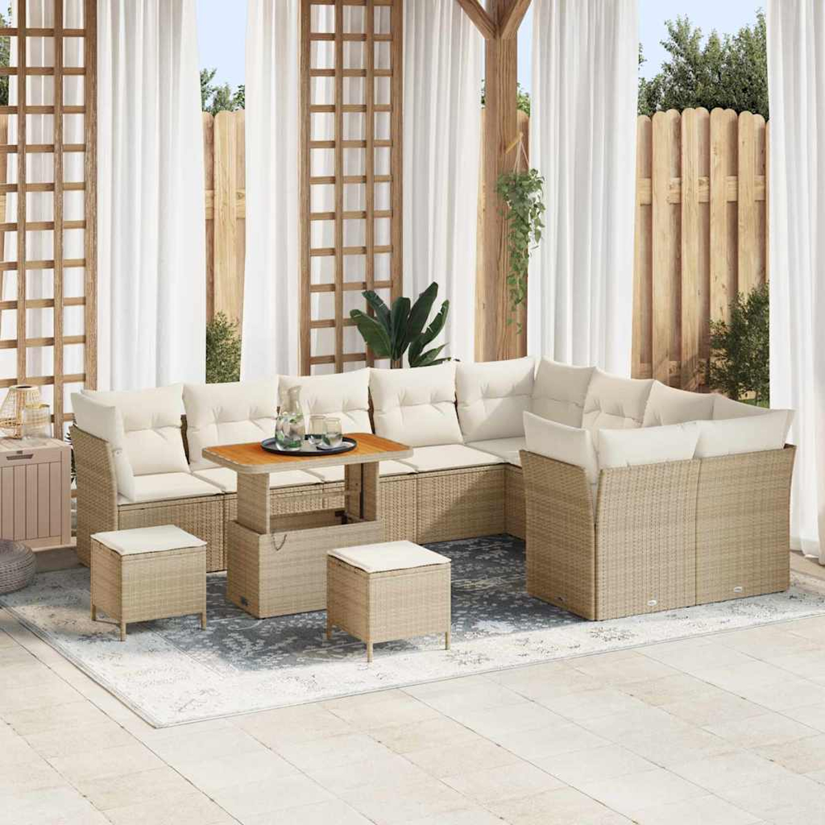 Outdoor-Ecksofa mit beigefarbenen Kissen und gewebter Basis. Ein Holztisch und Hocker stehen auf einem Teppich, mit transparenten Vorhängen im Hintergrund.