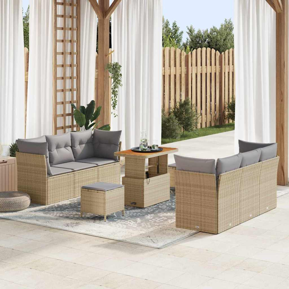 Outdoor-Terrassenset mit beigefarbenen Korbsesseln und grauen Kissen. Ein Tisch und ein Hocker stehen auf einem gemusterten Teppich, Vorhänge im Hintergrund.