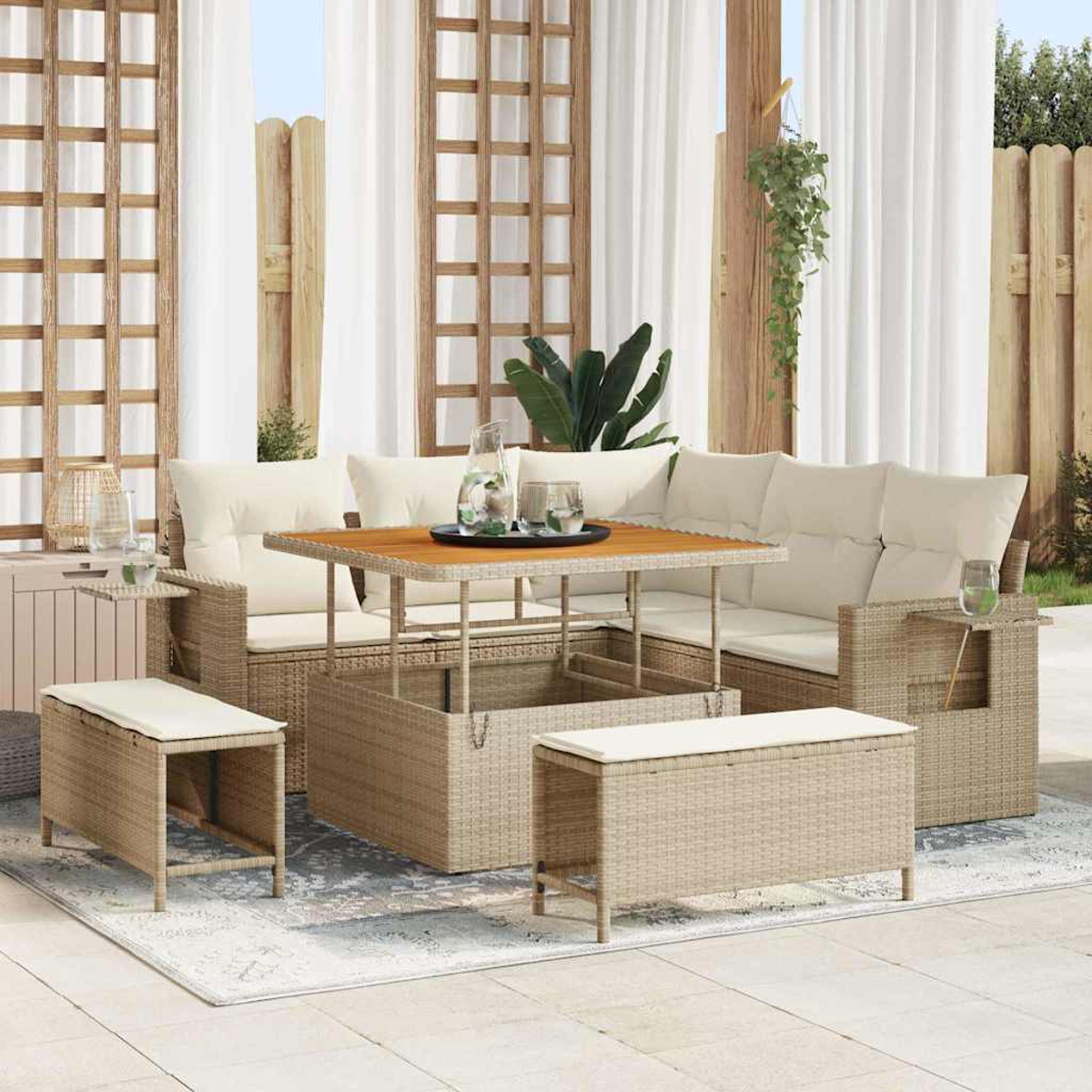 Gartenmöbel-Set aus Rattan mit Tisch, Sofa und Bänken. Die Szene ist eine Terrasse mit weißen Vorhängen und einem Holzzaun.