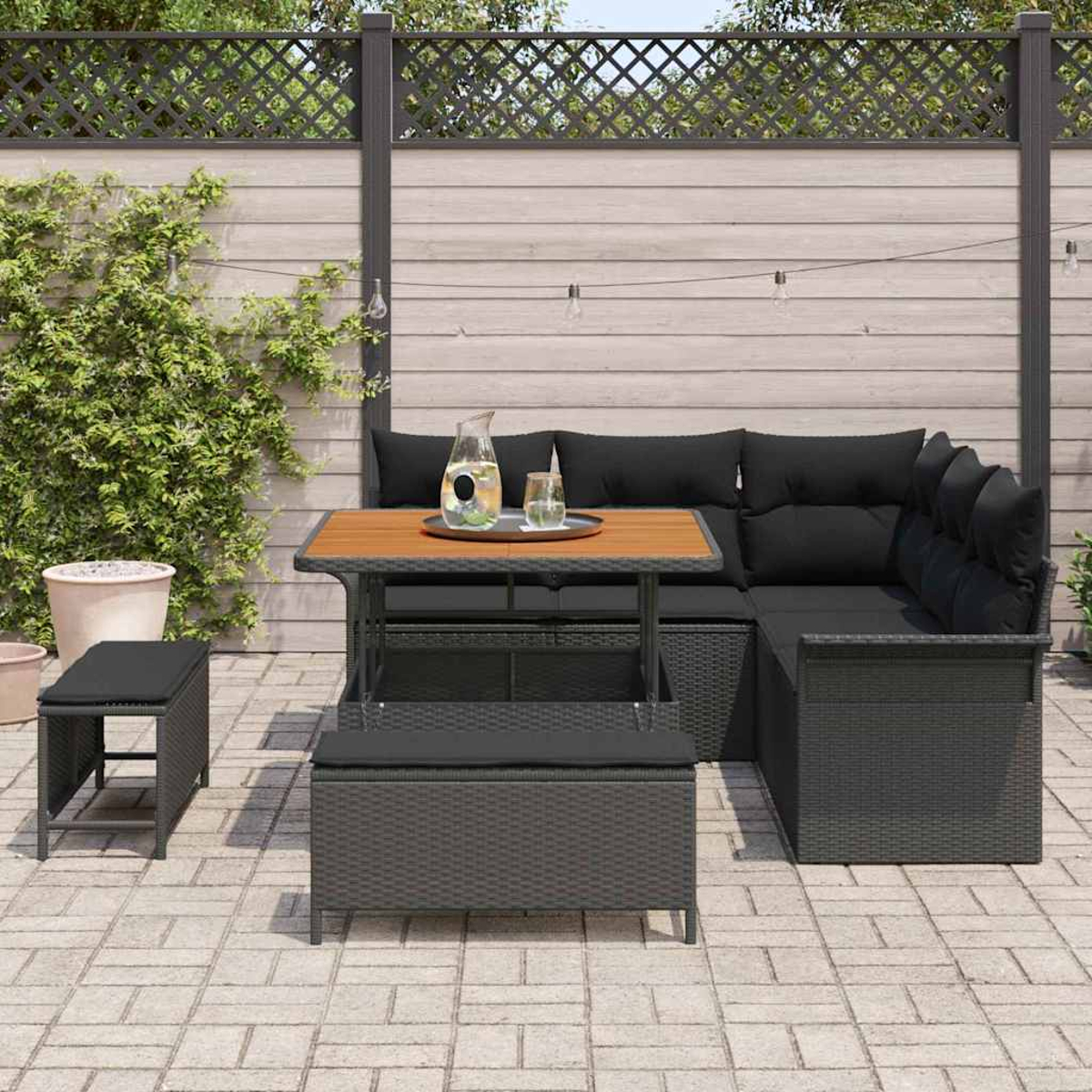Set di mobili da patio con cuscini neri e tavolo in legno. Include una panca, uno sgabello e un divano angolare.