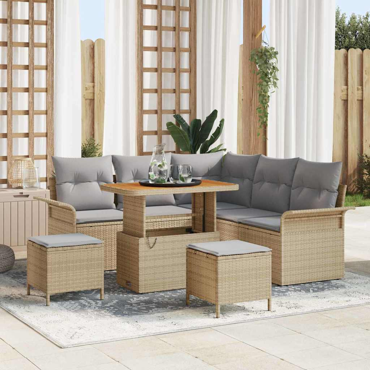 Outdoor-Rattan-Möbel-Set mit grauen Kissen, Tisch mit Gläsern und Krug sowie einem Teppich auf der Terrasse.