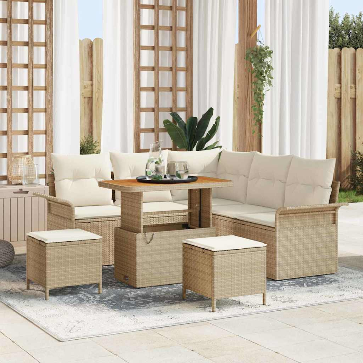 Set di mobili da esterno in vimini con cuscini beige. Include tavolo, divano, sedie e pouf su un tappeto fantasia.
