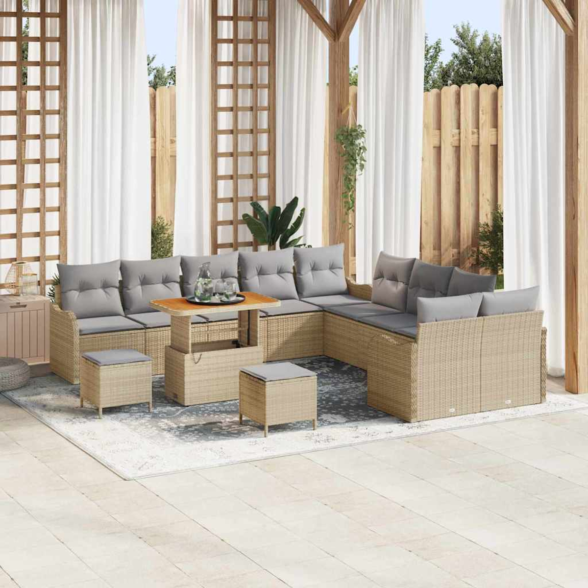 Outdoor-Ecksofa mit grauen Kissen, Couchtisch und Hockern. Weiße Vorhänge und Holzzaun im Hintergrund.