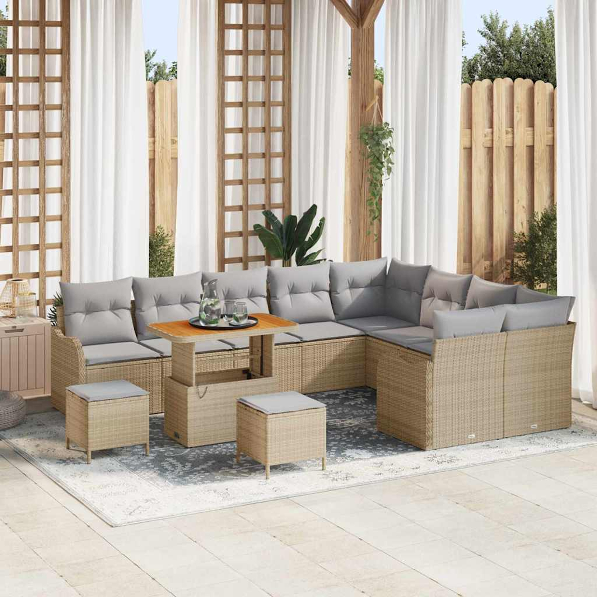 Ein Sitzbereich im Freien mit Ecksofa, Ottomanen und einem Couchtisch. Weiße Vorhänge und ein Holzzaun sind im Hintergrund zu sehen.