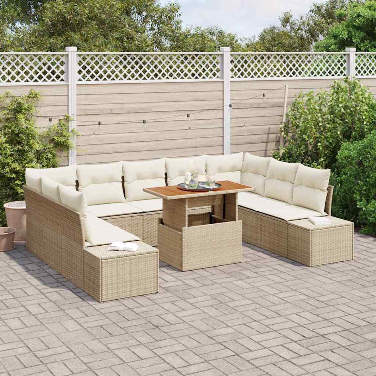 Outdoor-Wicker-Ecksofa mit beigen Kissen, einem Holztisch und einem weißen Gitterzaun im Hintergrund auf einer gepflasterten Terrasse.