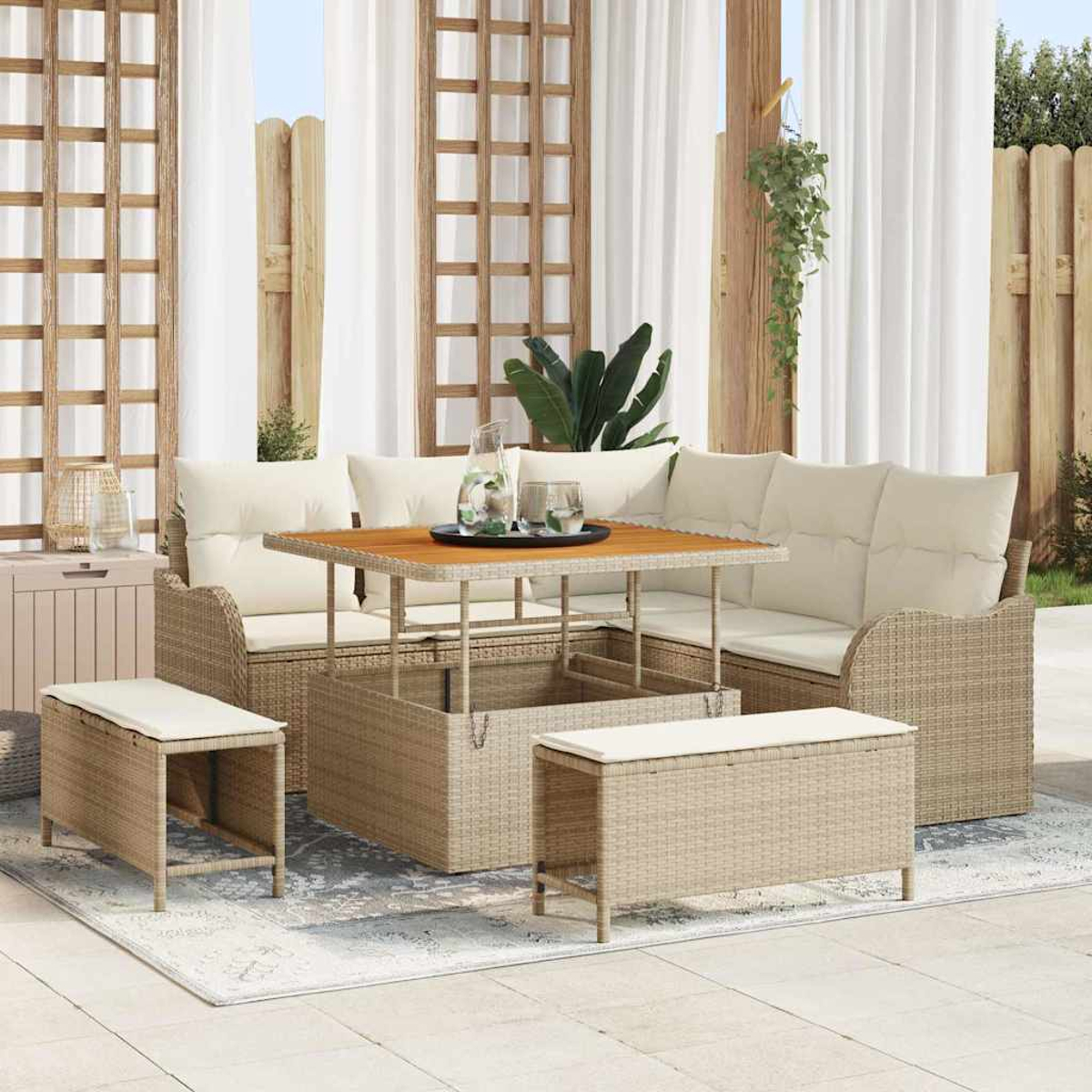 Sitzbereich im Freien mit einem Sofas aus Korbweide, Bänken und einem Holztisch auf einem gemusterten Teppich.