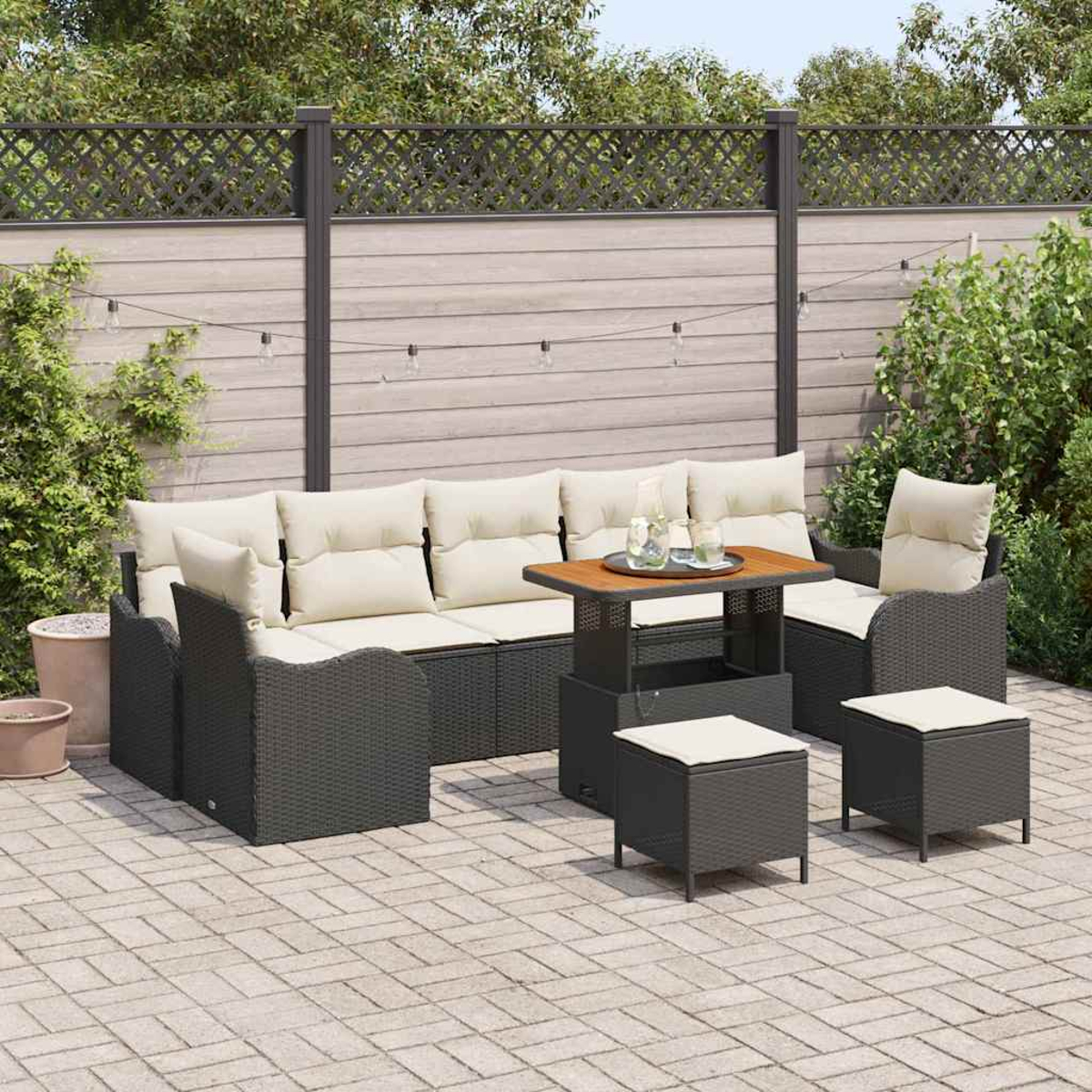 Garten-Terrassenset mit dunkelgrauen Korbmöbeln, cremefarbenen Kissen und einem Holztisch. Der Hintergrund umfasst einen Zaun und Grün.