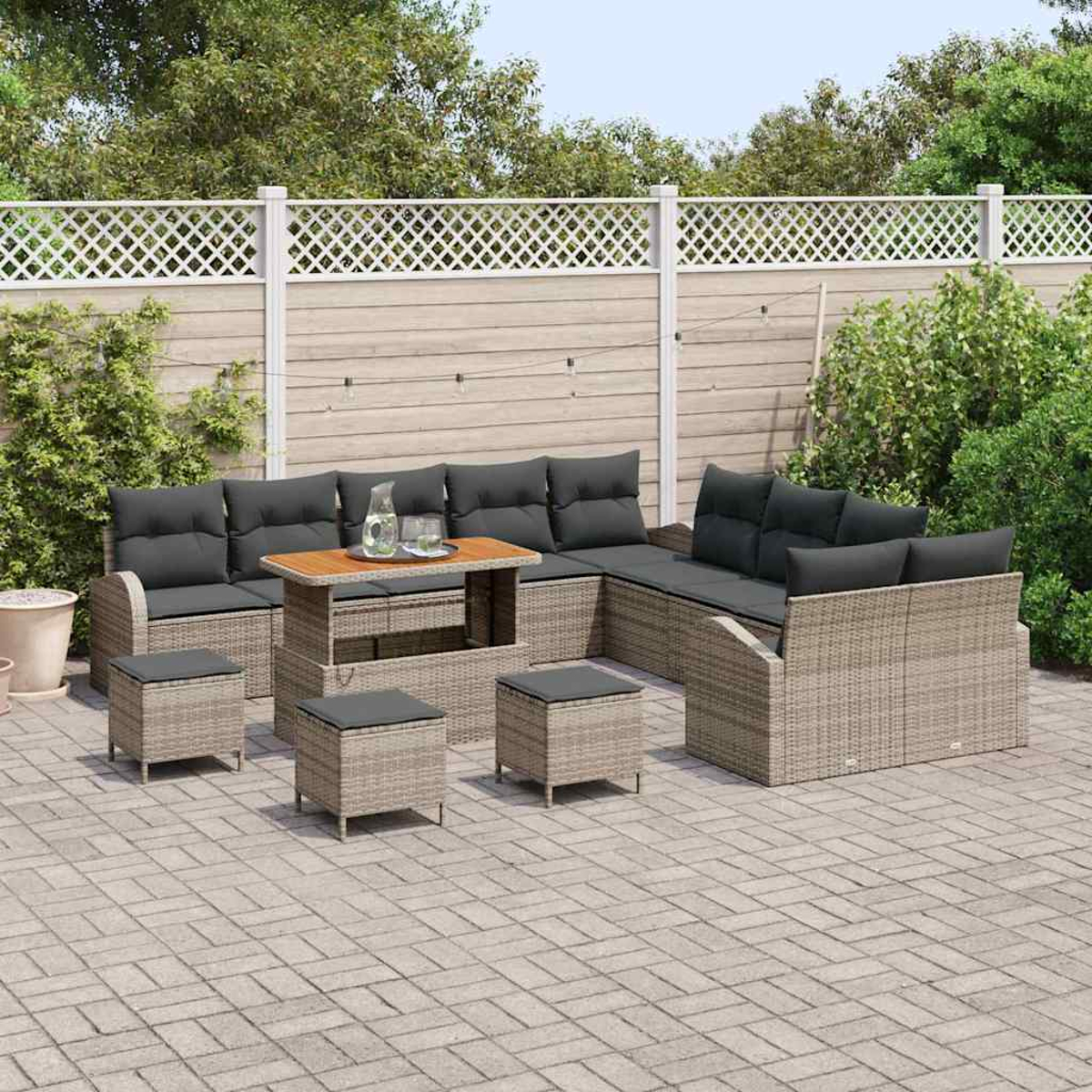 Garten-Sitzgruppe: Rattan-Sofa mit grauen Kissen, Holztisch und passenden Ottomanen. Auf Steinterrasse, mit Zaun und Grün.