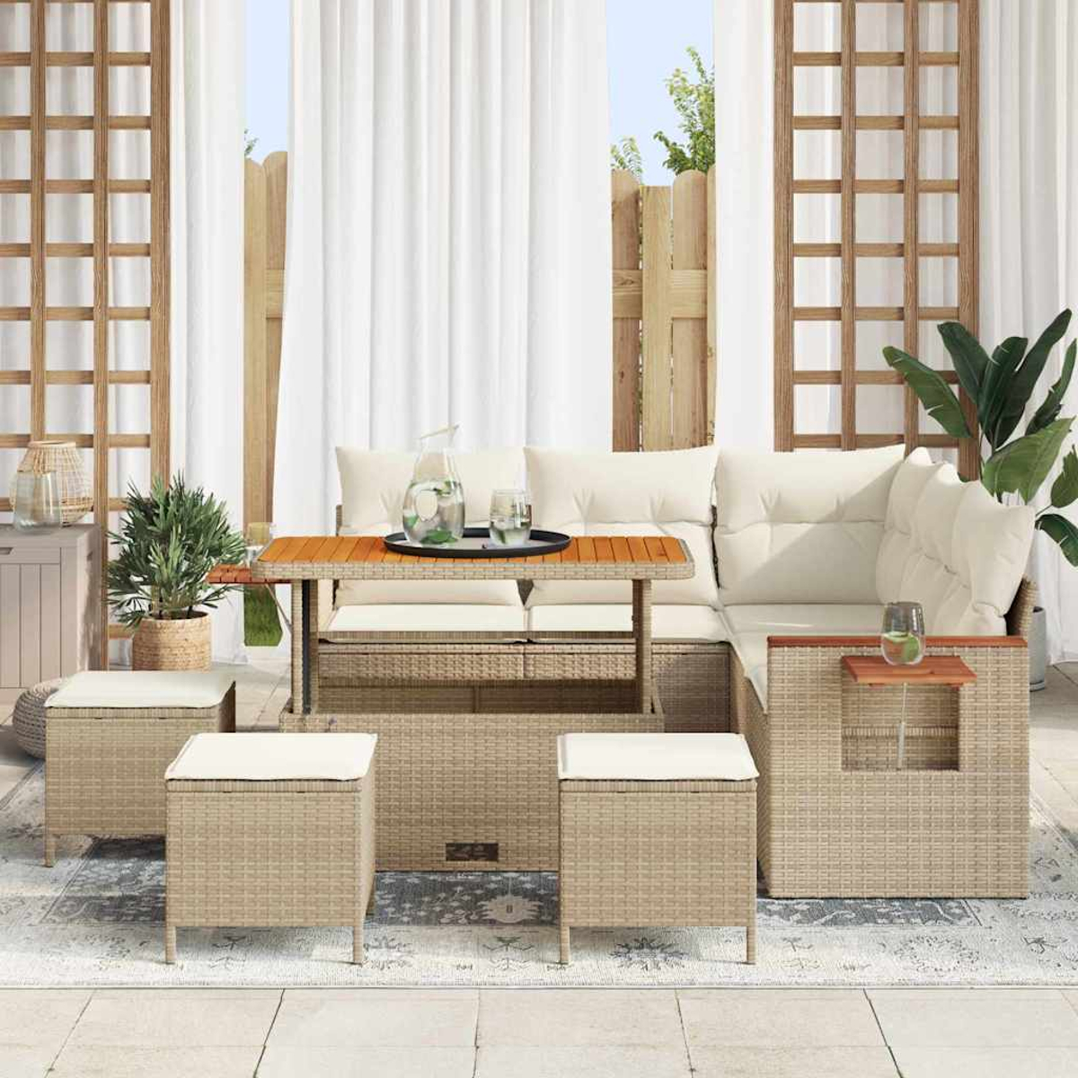 Gartenmöbel-Set aus Rattan mit Tisch, Sofa, Ottomanen und Pflanzen. Weiße Vorhänge und hölzernes Gitter im Hintergrund.
