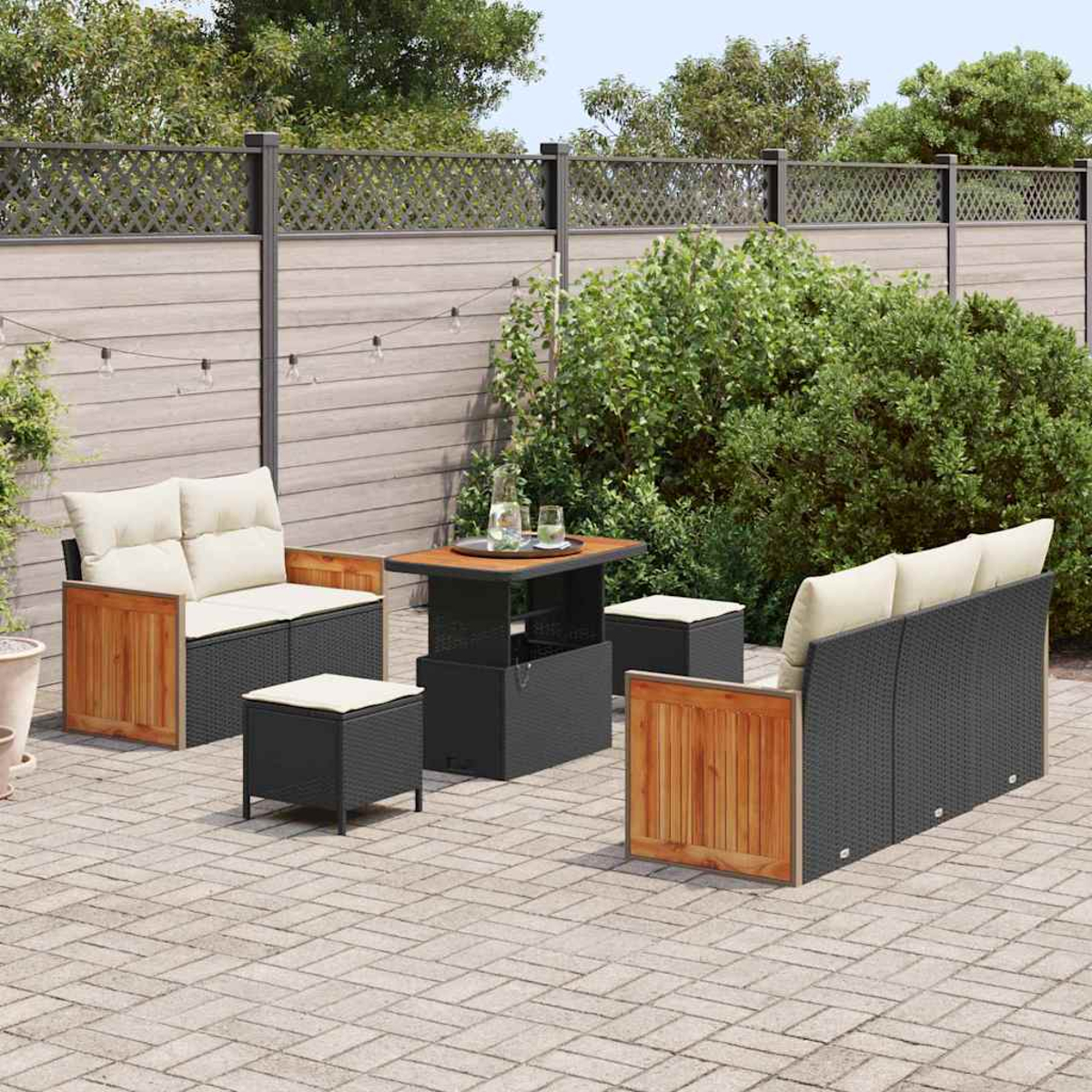 Set da patio esterno con divano, sedie e tavolo. Una recinzione in legno e verde formano lo sfondo, con un patio in mattoni.