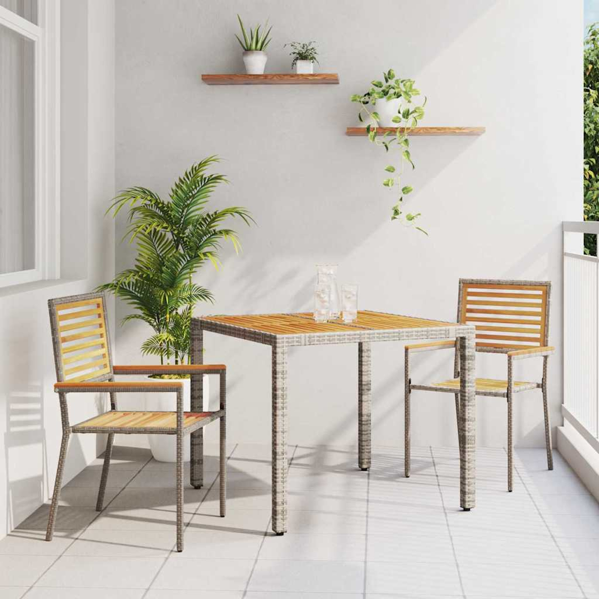 Balkon mit Tisch, zwei Stühlen und Pflanzen. Der Tisch ist mit Gläsern gedeckt. Die Stühle sind aus Holz. Weiße Wand und Boden.