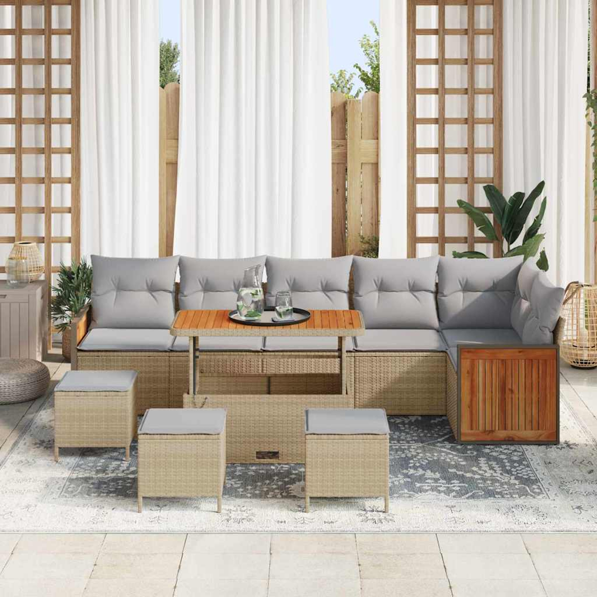 Terrassen-Set mit grauen Kissen, einem Holztisch und vier Ottomanen. Weiße Vorhänge und ein Holzzaun im Hintergrund.