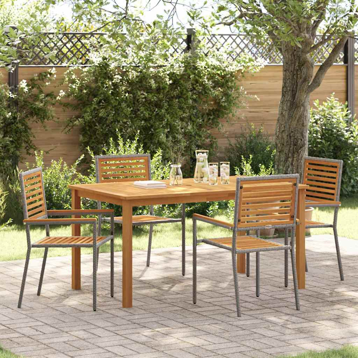 Essgruppe im Freien: Holztisch und Stühle auf einer Terrasse. Hintergrund: Grün, Zaun und Baum, die eine natürliche Umgebung schaffen.
