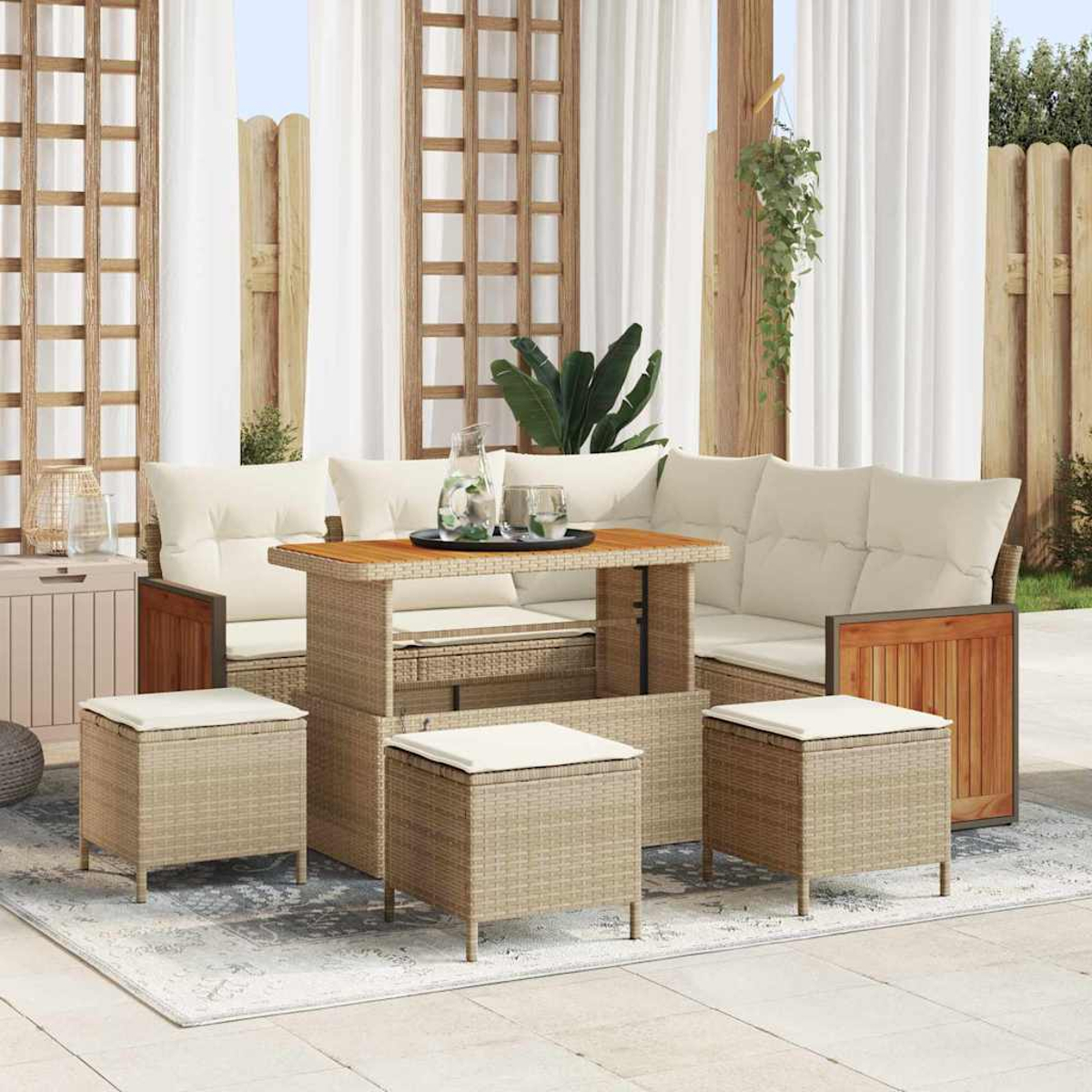 Terrassenset mit beigen Kissen, Holztisch und Korbstühlen. Weiße Vorhänge und Holzzaun sorgen für eine gemütliche Atmosphäre.