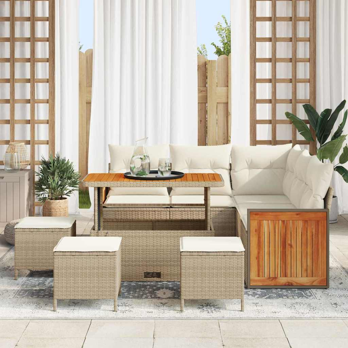 Gartenmöbel-Set aus Korbgeflecht mit Kissen, Tisch und Hockern. Weiße Vorhänge und ein Holzzaun sind im Hintergrund zu sehen.