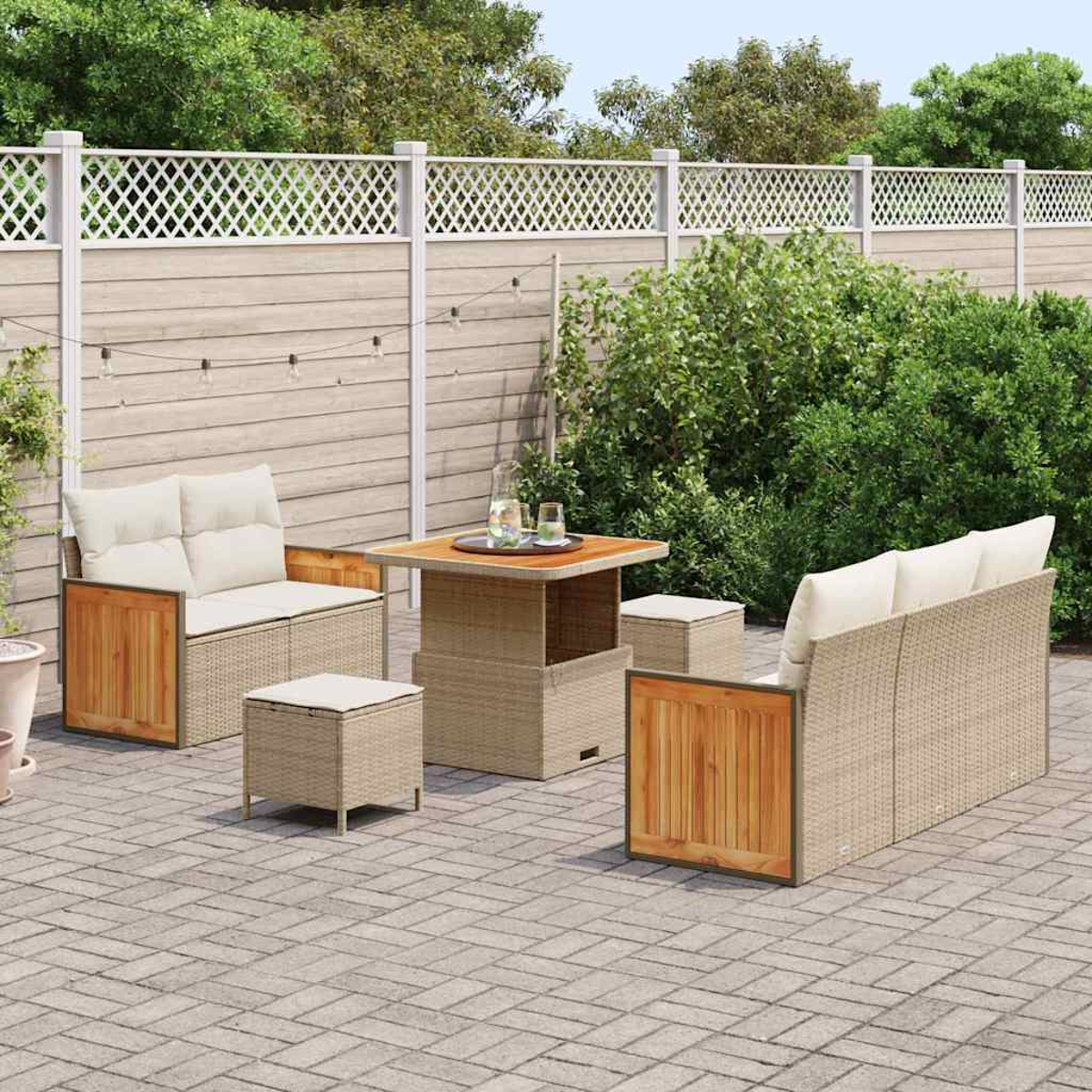 Garten-Terrassenset mit Korbmöbeln, Holzakzenten und beigen Kissen. Ein Tisch und zwei Hocker stehen auf einer Ziegelterrasse.