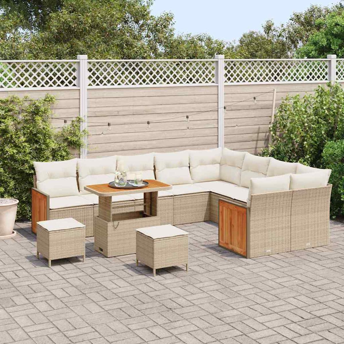 Ein Outdoor-Terrassenset mit Ecksofa, Tisch und zwei Hockern. Das Sofa hat cremefarbene Kissen und der Tisch eine Holzplatte. Im Hintergrund befindet sich ein weißer Zaun.