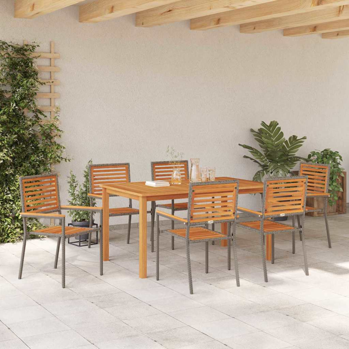 Essgruppe im Freien: Holztisch und Stühle. Im Hintergrund Pflanzen, ein Spalier und eine weiße Wand unter Holzbalkendecke.