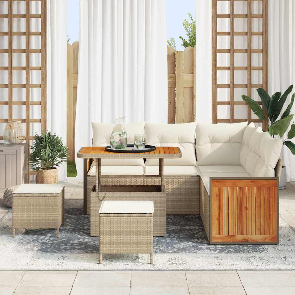 Terrassenmöbel-Set mit Rattanstil, darunter ein Ecksofa, Tisch und Ottomanen. Weiße Vorhänge und Pflanzen im Hintergrund.