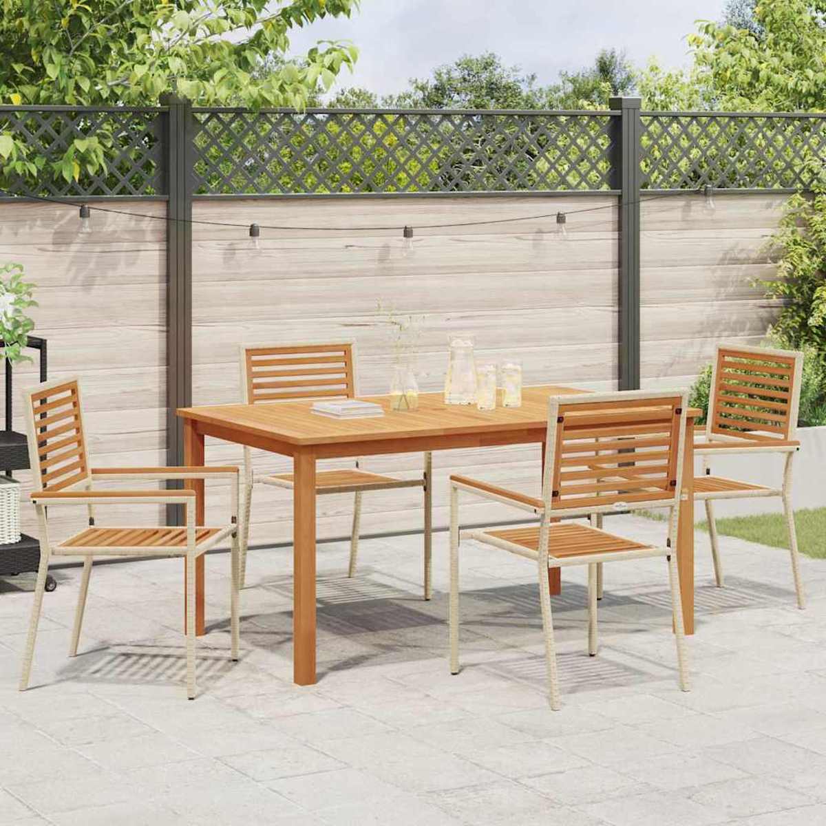 Set da pranzo all'aperto con tavolo e sedie in legno. Una recinzione e vegetazione sullo sfondo. Il patio è fatto di piastrelle quadrate.