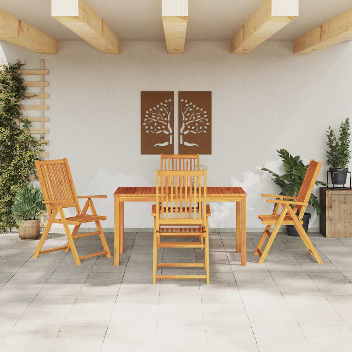 Terrassengarnitur im Freien mit Holztisch, Stühlen und dekorativer Baumkunst an der Wand. Grüne Pflanzen und Holzbalken vervollständigen die Szene.