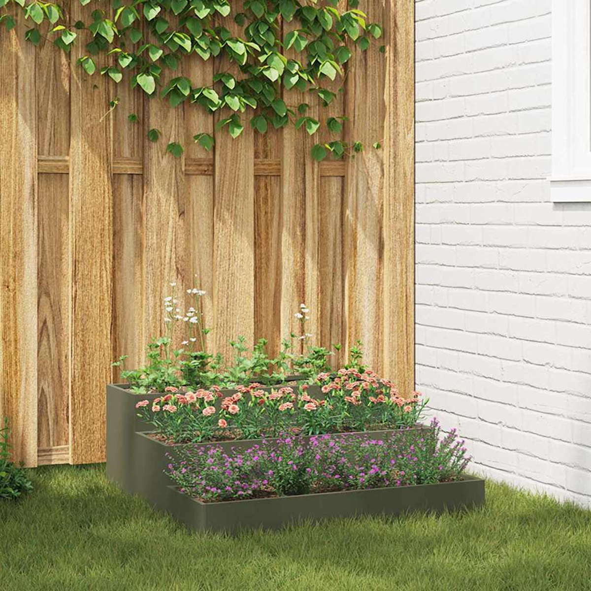 Una fioriera a più livelli con fiori è sull'erba. Sullo sfondo una staccionata in legno e un muro di mattoni bianchi, con rampicanti.