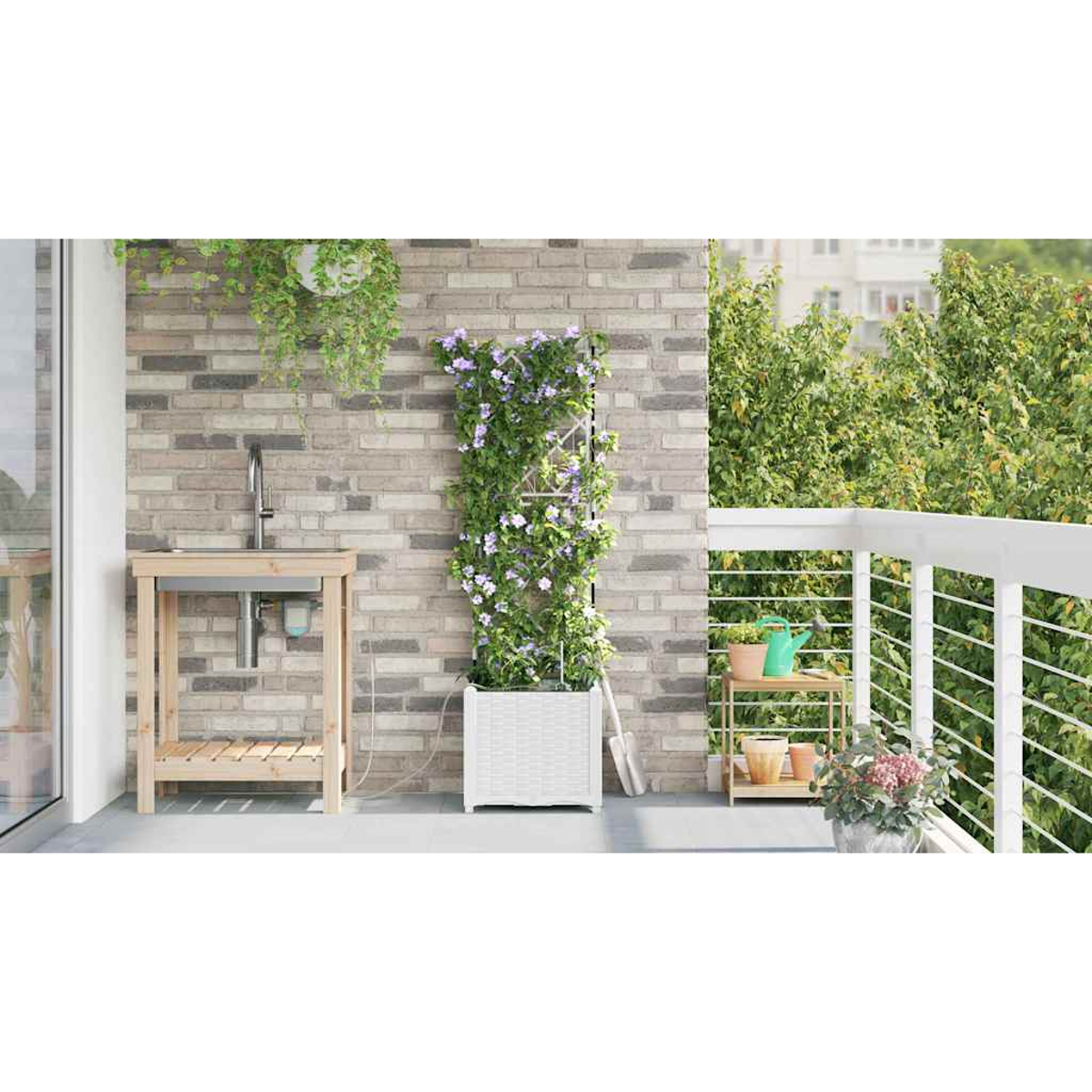 Scena di balcone con muro di mattoni, lavandino, piante e fioriera bianca con fiori. Si vede uno sfondo verde foglioso e una ringhiera bianca.