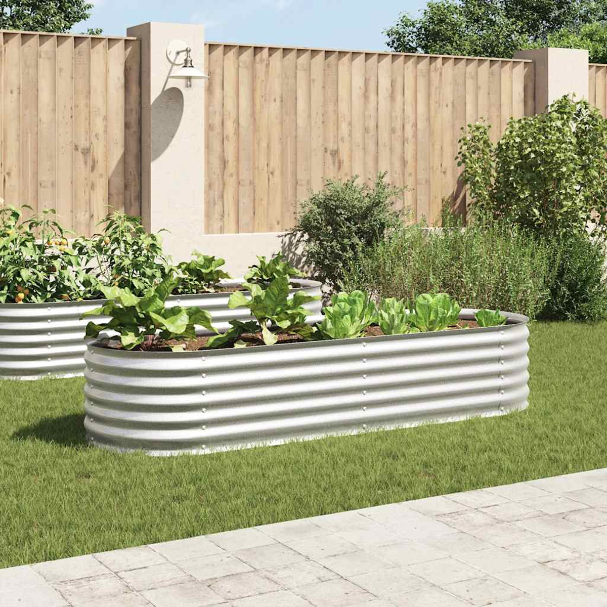 Gemüsegarten mit drei Metallpflanzgefäßen auf Rasen. Im Hintergrund ein Holzzaun.