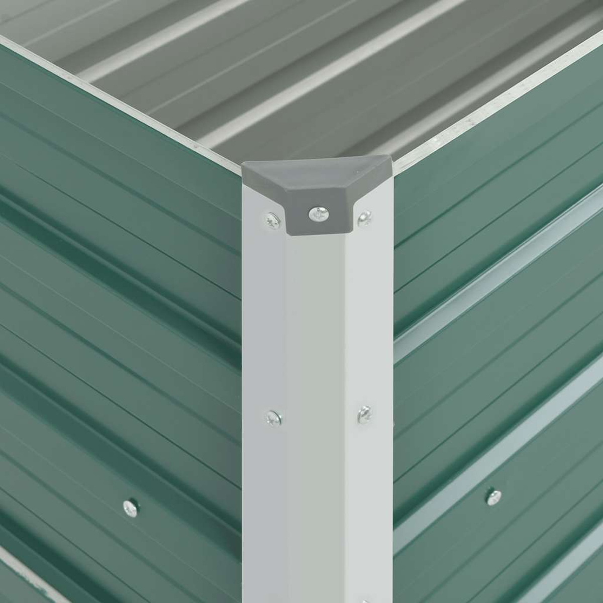 Nahaufnahme einer Metallecke. Grüne Wellplatten treffen auf eine weiße Eckpfosten mit grauer Kappe. Verbindungselemente sichern die Komponenten.