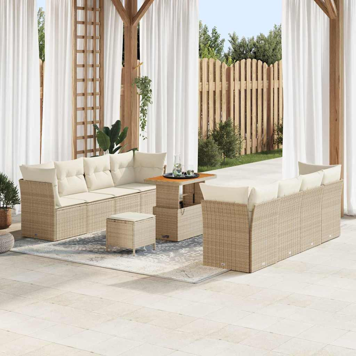 Terrassenset mit beigefarbenen Korbsesseln, cremefarbenen Kissen, einem kleinen Tisch und einem Hocker unter weißen Vorhängen und Holzbalken.
