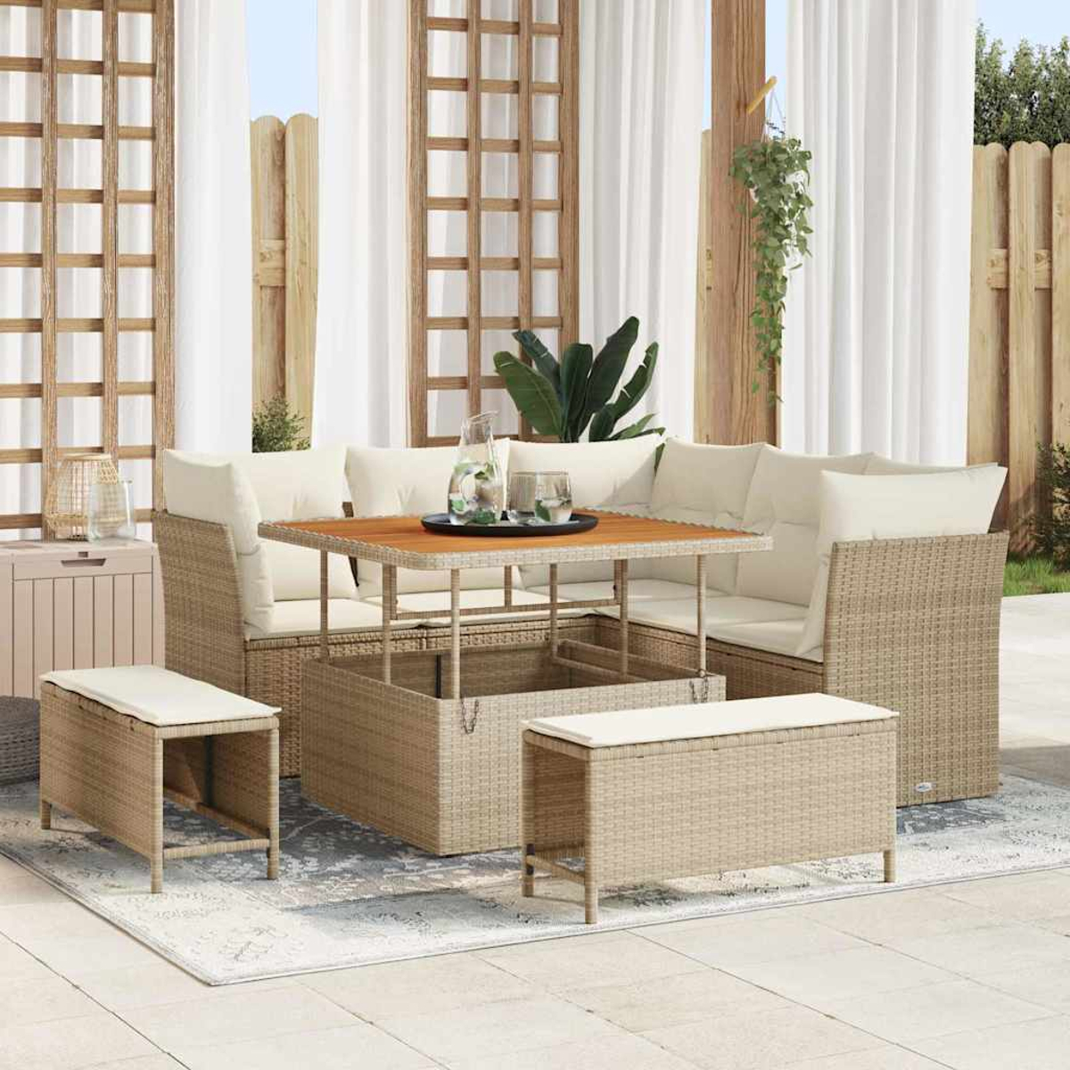 Outdoor-Ecksofa mit beigen Kissen und Holztisch. Zwei Bänke und eine Aufbewahrungsbox. Weiße Vorhänge und Holzzaun.