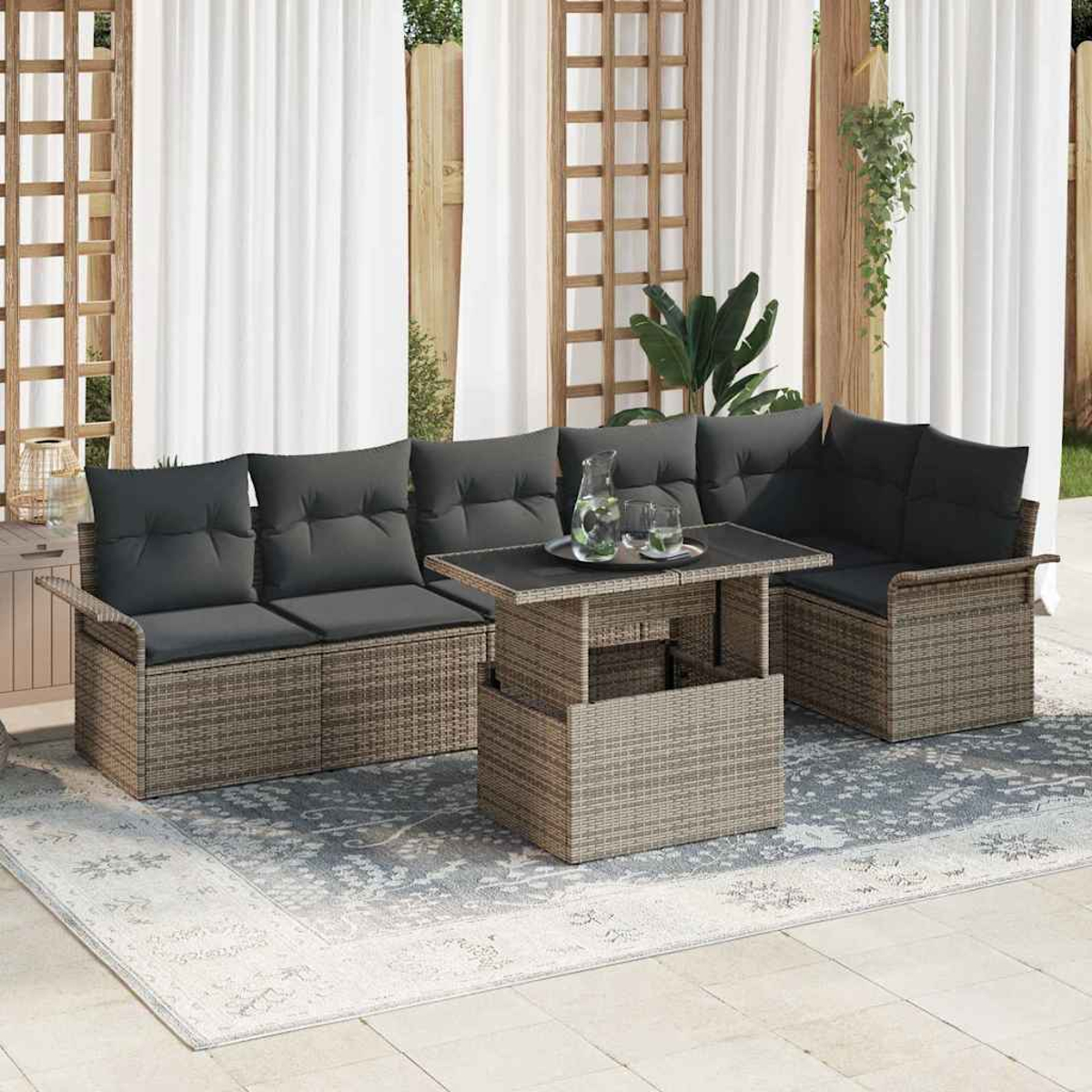 Terrassenmöbel mit grauen Kissen, einem Tisch und einem Teppich. Hintergrund mit weißen Vorhängen und Holzgitter.