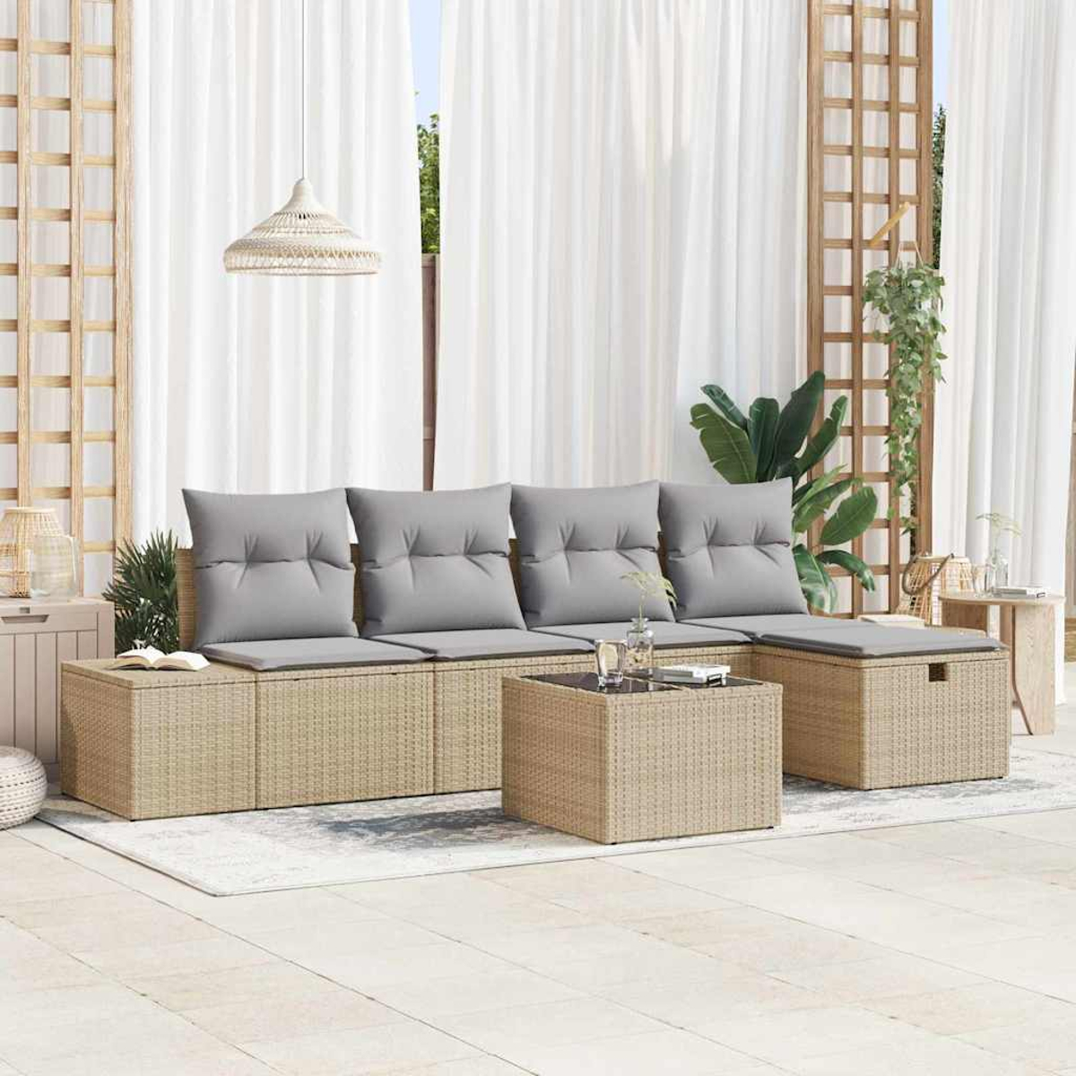 Garten-Sitzgruppe mit grauen Kissen, einem Couchtisch und weißen Vorhängen im Hintergrund.