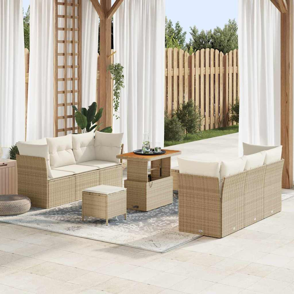 Terrassenset: zwei Sofas, eine Ottomane und ein Tisch mit Hubfunktion auf einem gemusterten Teppich. Weiße Vorhänge und Holzzaun im Hintergrund.