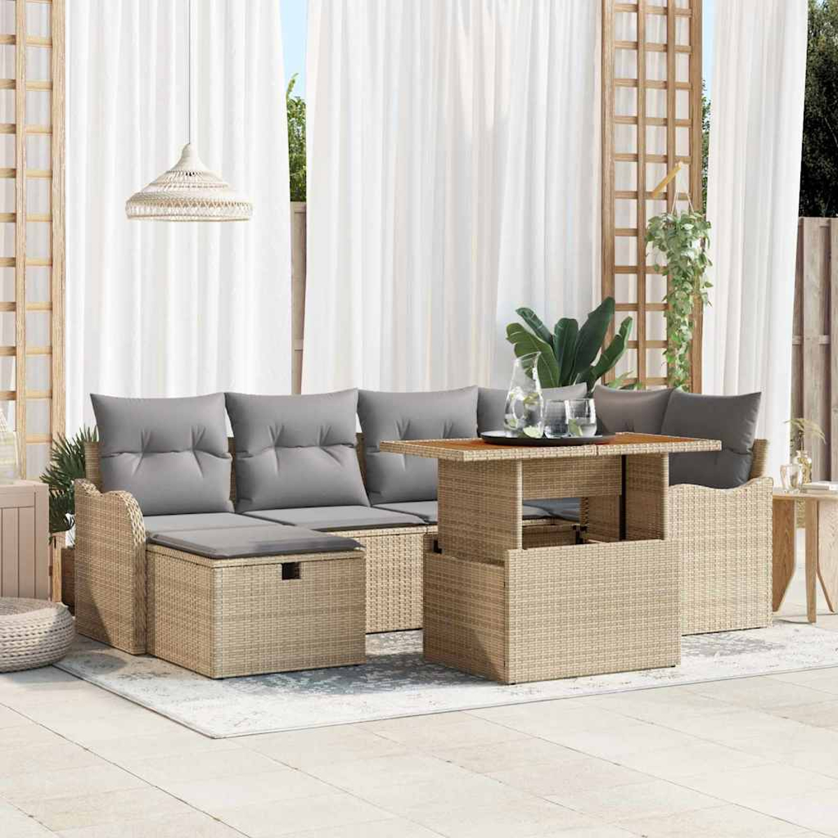 Gartenmöbel-Set mit grauen Kissen, Korbtisch und weißen Vorhängen. Pflanzen und eine Hängelampe sind ebenfalls sichtbar.