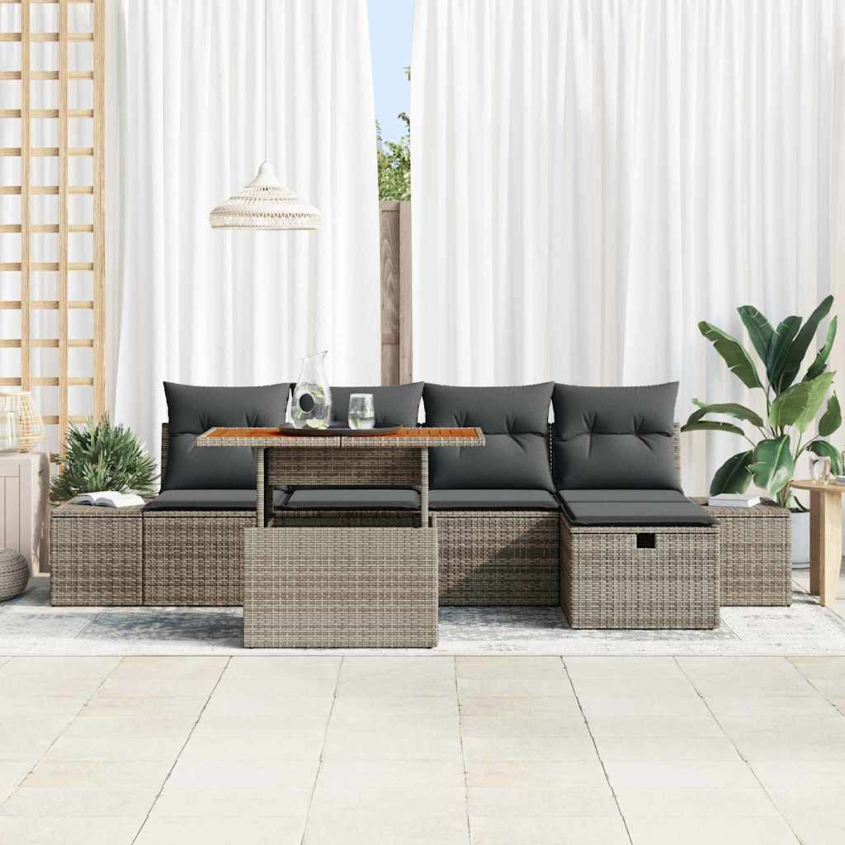 Garten-Terrassenset mit grauen Kissen, einem Tisch mit Holzplatte und weißem Vorhang im Hintergrund. Rechts ist eine Pflanze.