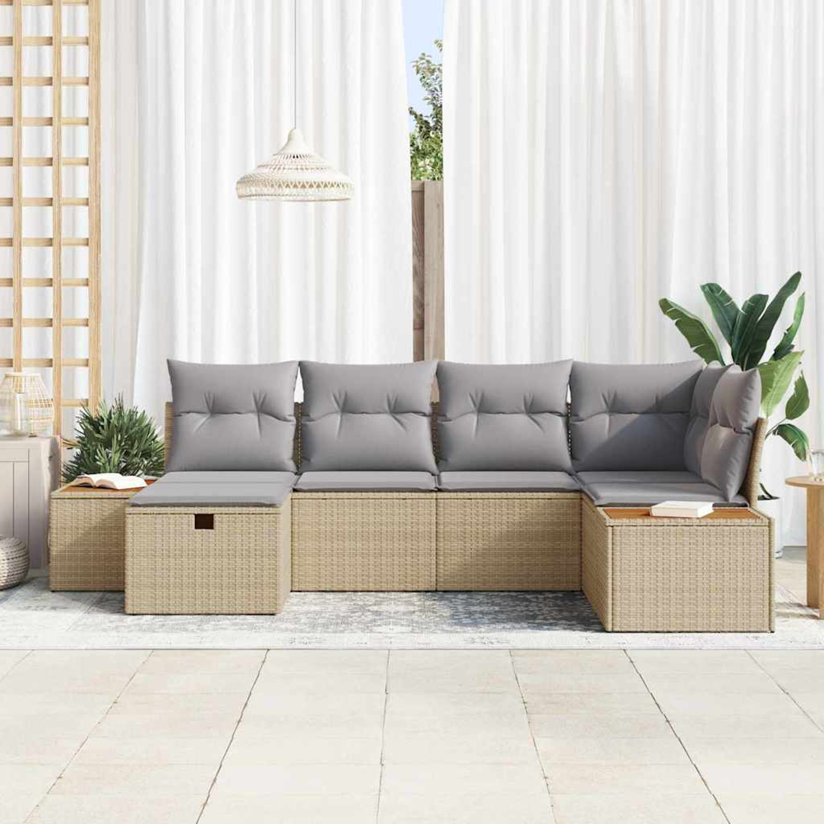 Ein hellbeige-farbenes Rattan-Ecksofa mit grauen Kissen steht auf einer Terrasse. Im Hintergrund befinden sich weiße Vorhänge und eine Hängeleuchte.